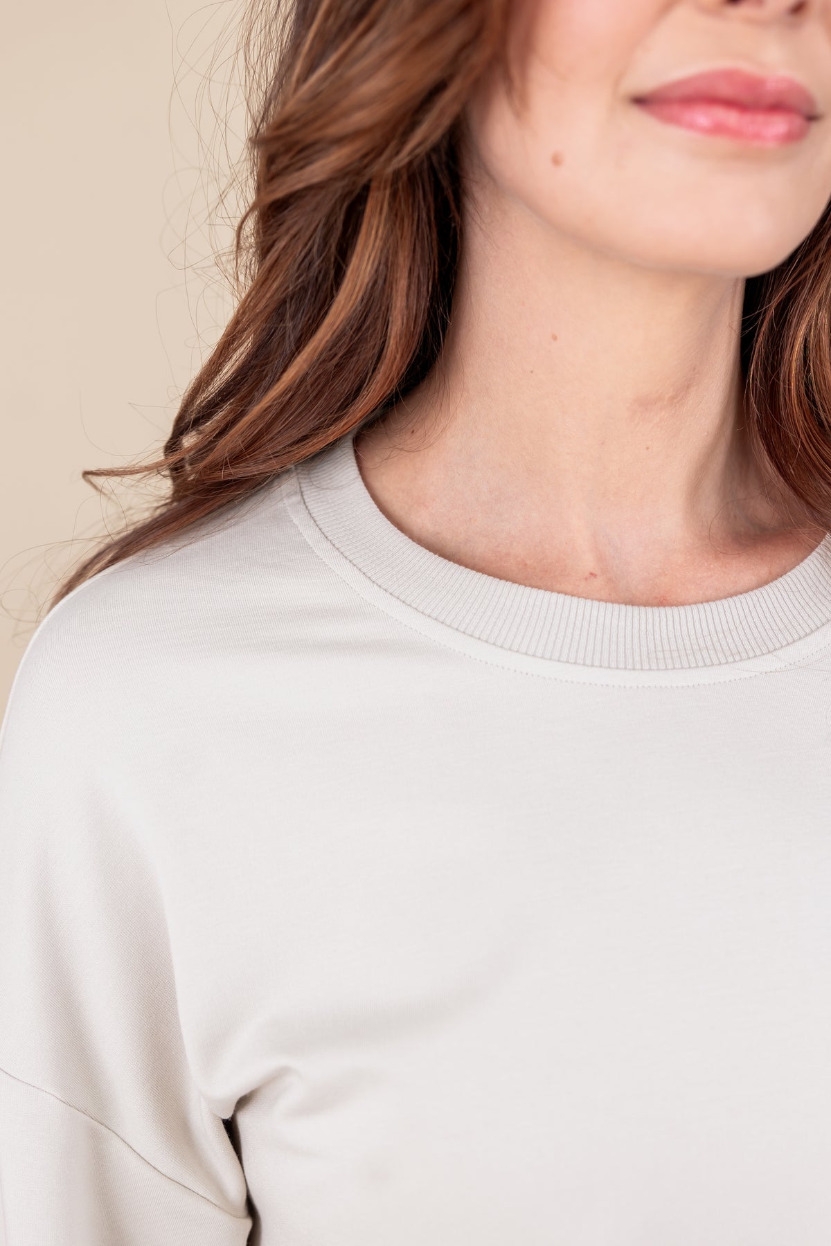 Close up of Woman wearing Women's Sweatshirt in Oat color on a beige background