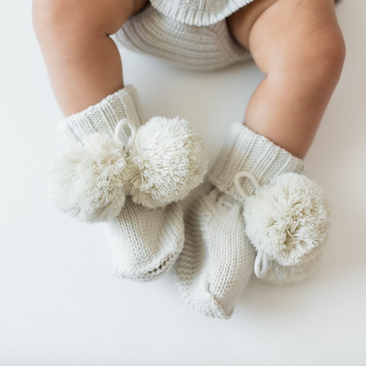 Knit Booties in Oat shown on an infant