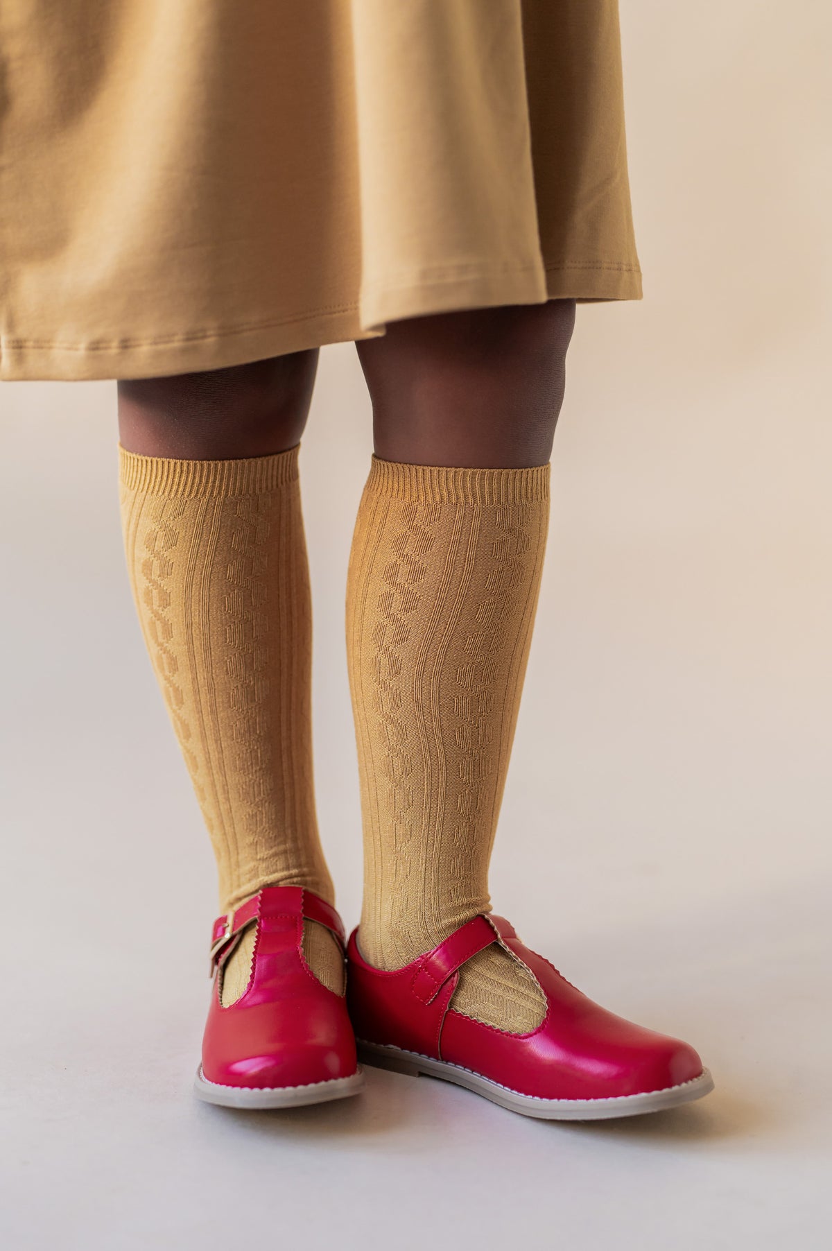 Modal wearing Knee High Socks in Ochre color with red shoes.