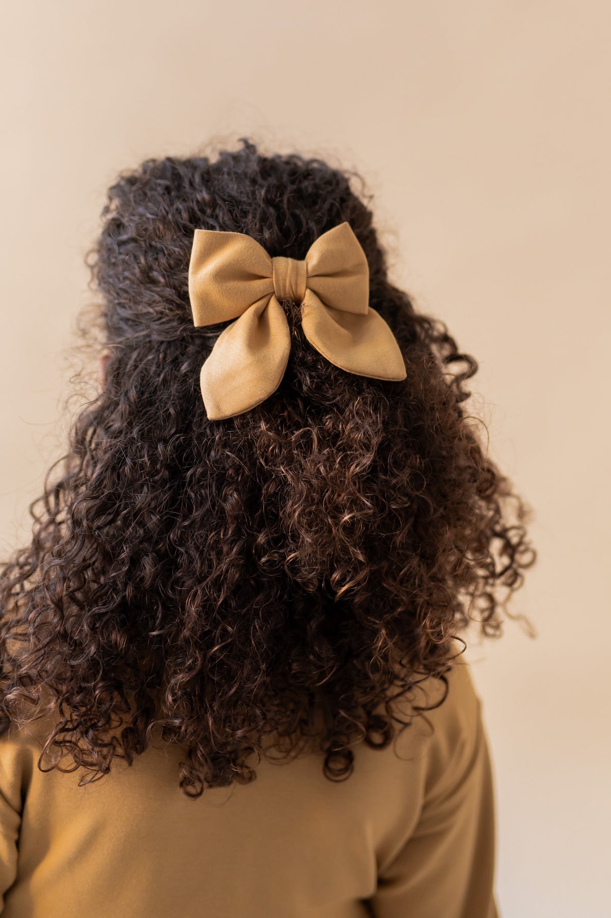 Modal wearing Medium Alligator Clip Bow in Ochre color in her hair. 