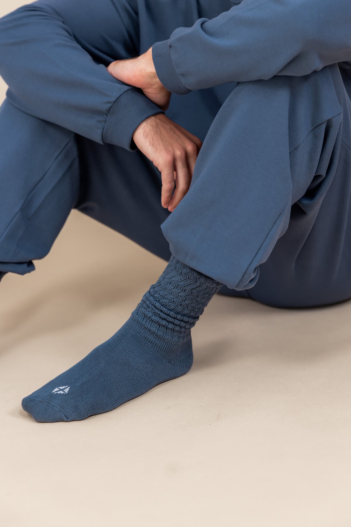 Modal wearing Adult Scrunch Socks in Oxford color while wearing jogger set in oxford color on a beige background