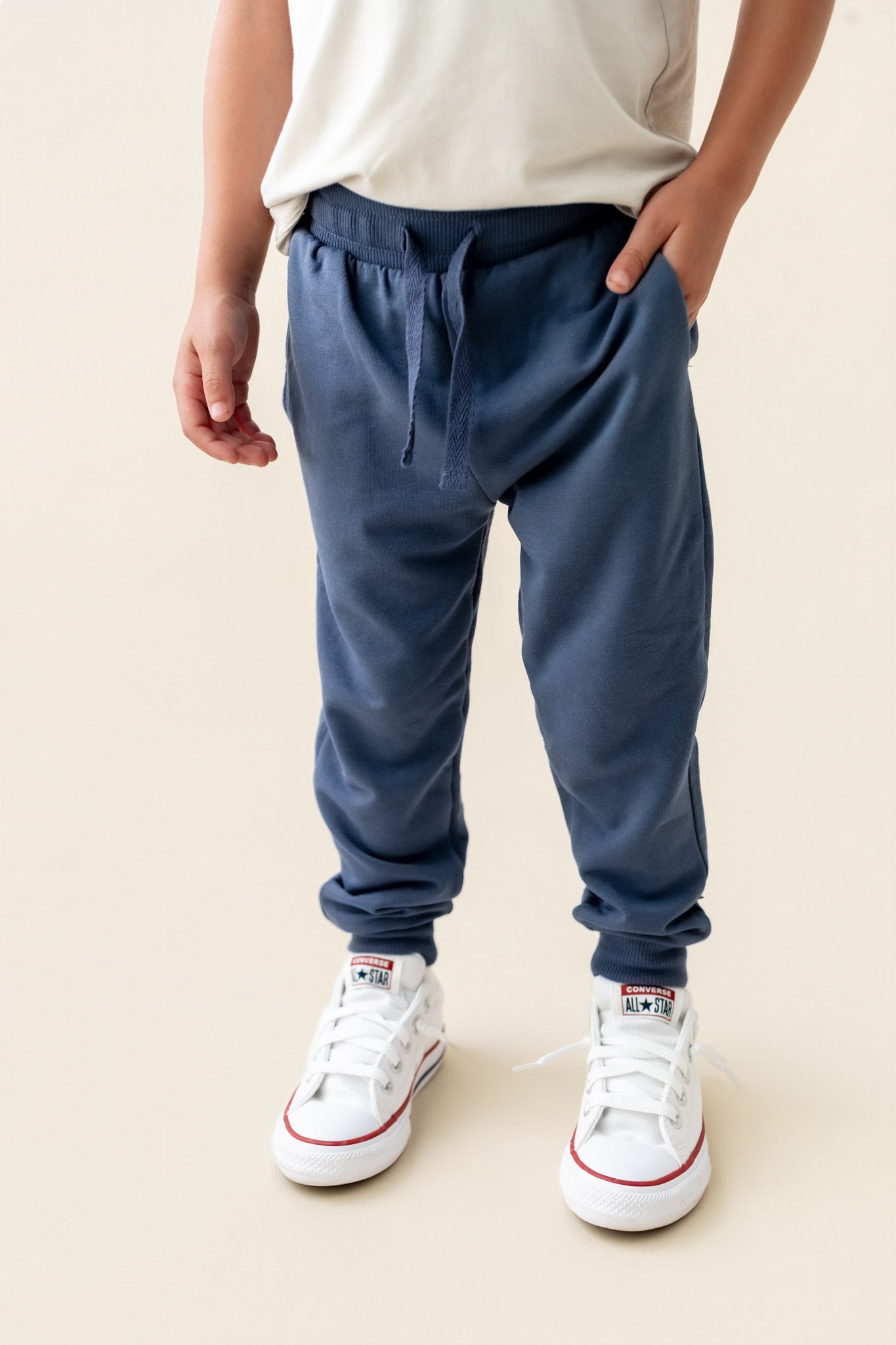 Modal wearing Jogger Pant in Oxford color under white T-shirt on a beige background