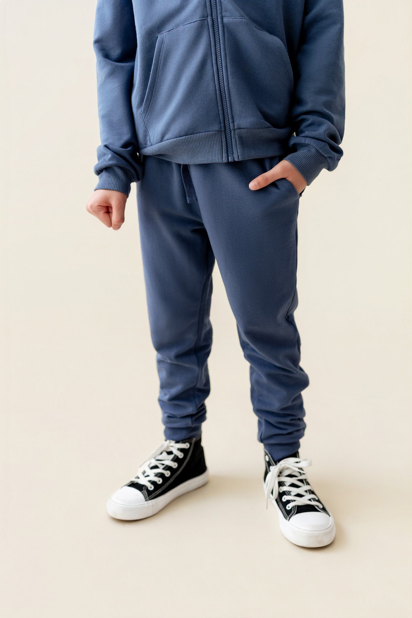 Modal wearing Jogger Pant in Oxford color under similar color hoodie on a beige background