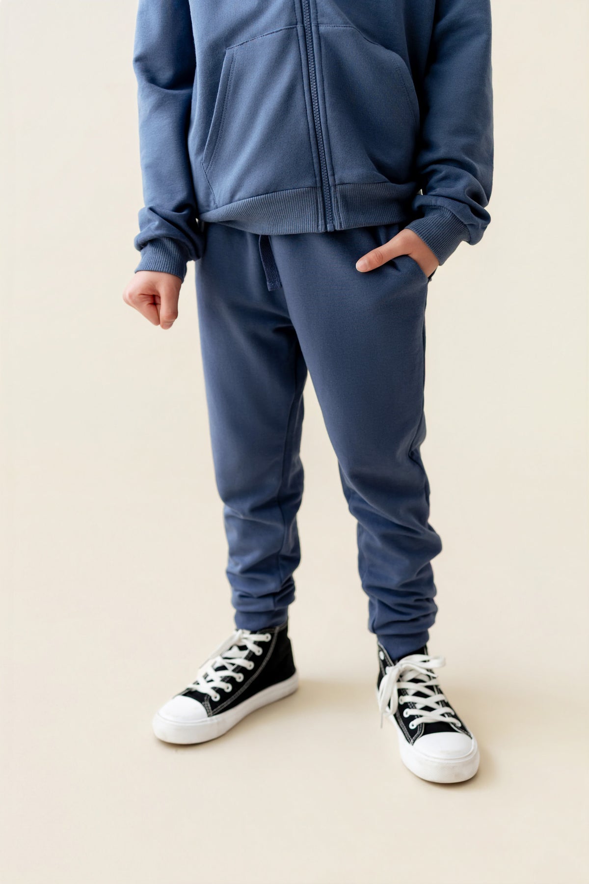 Modal wearing Jogger Pant in Oxford color under similar color hoodie on a beige background