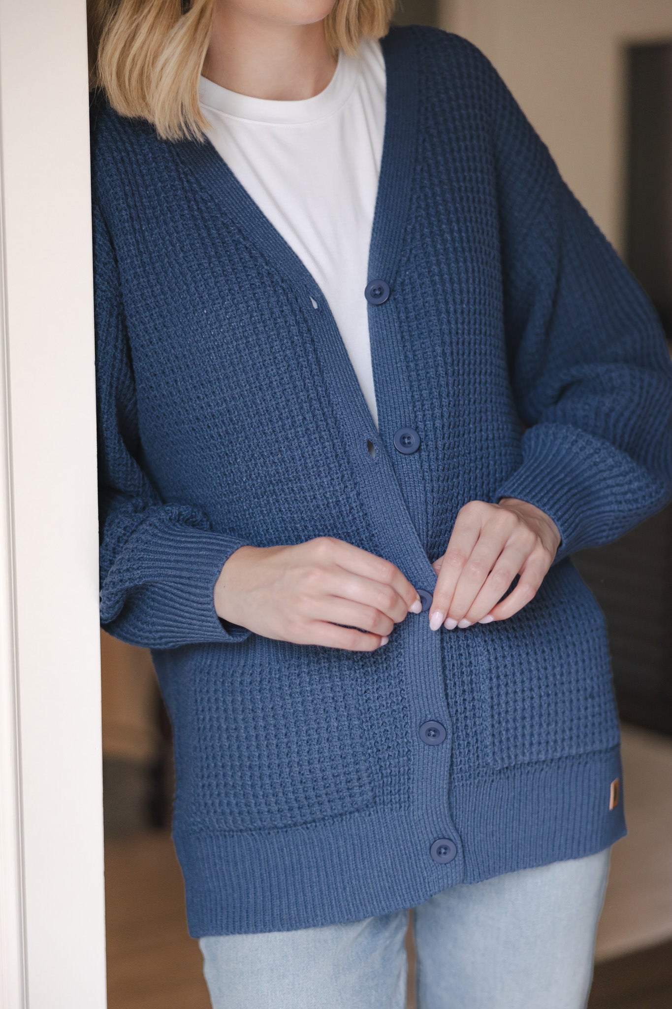 Modal buttoning the Chunky Knit Women's Waffle Cardigan in Oxford over white T-shirt and blue jeans