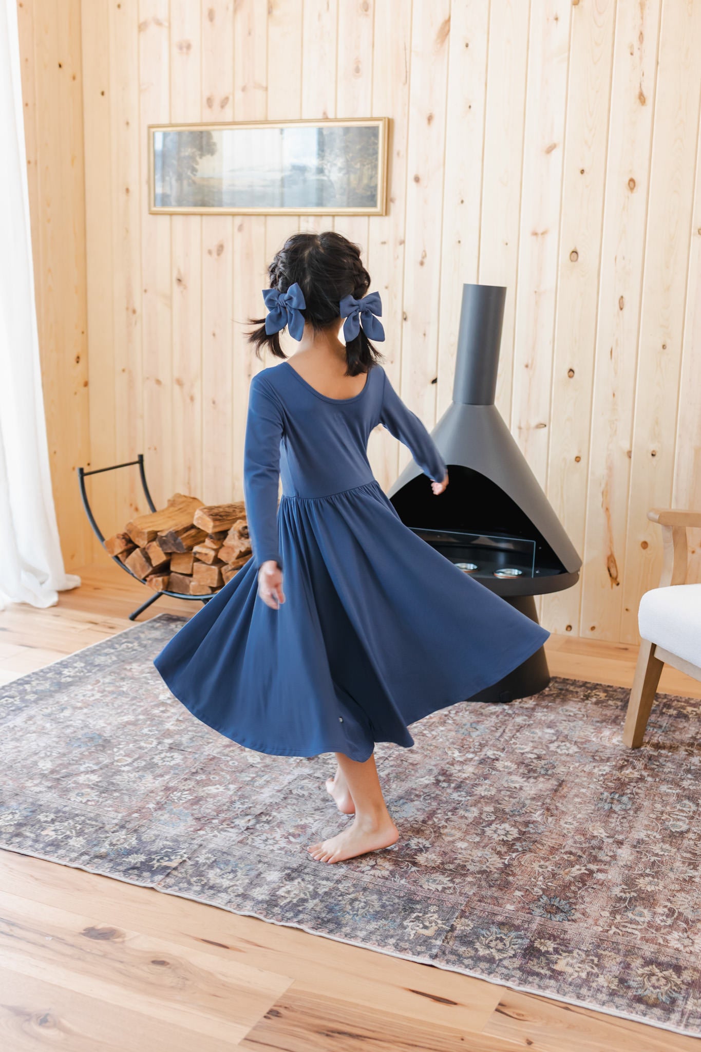 Girl twirling in Long Sleeve Twirl Dress in Oxford near a chimney