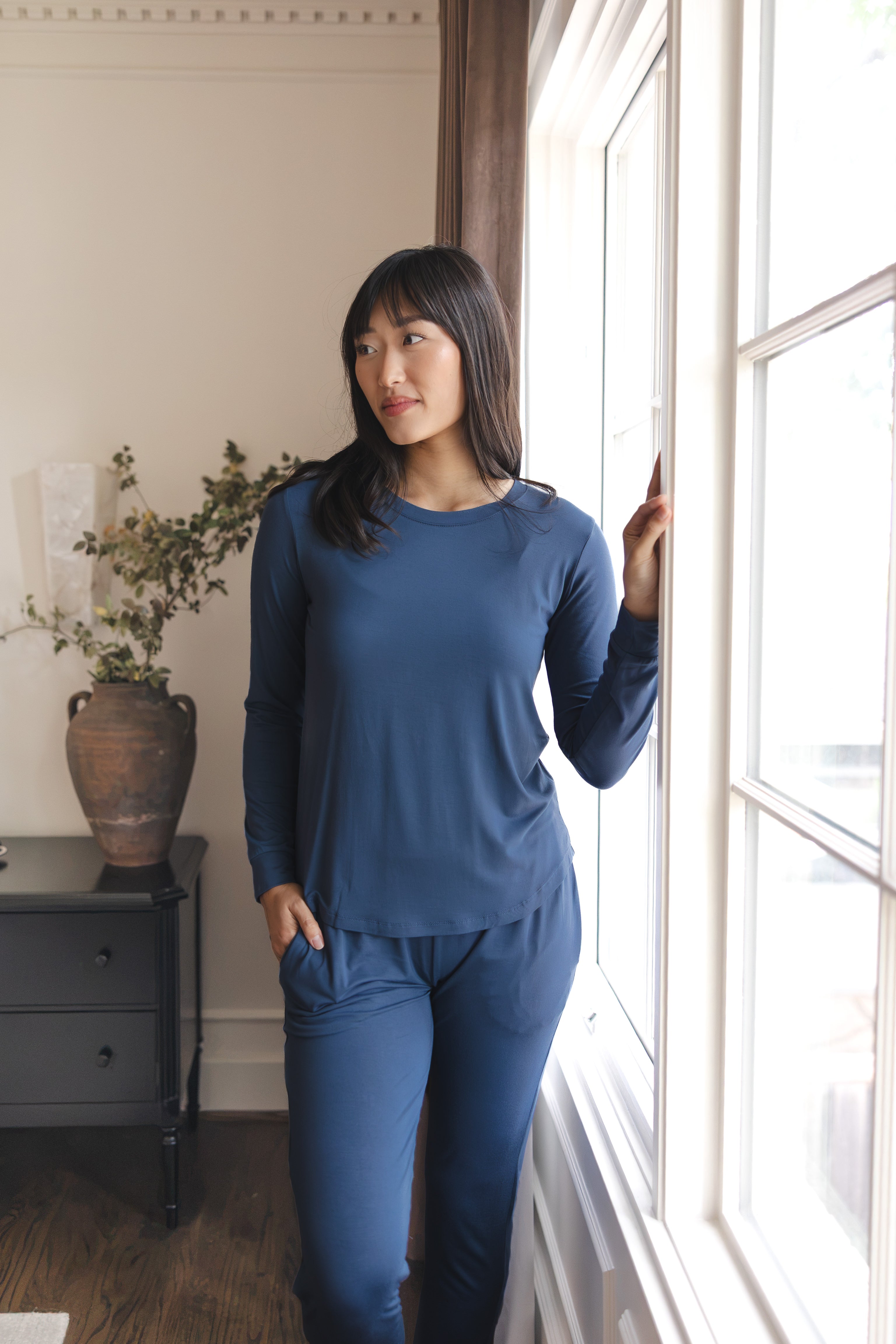Modal posing in Women's Jogger Pajama Set in Oxford standing near a glass window