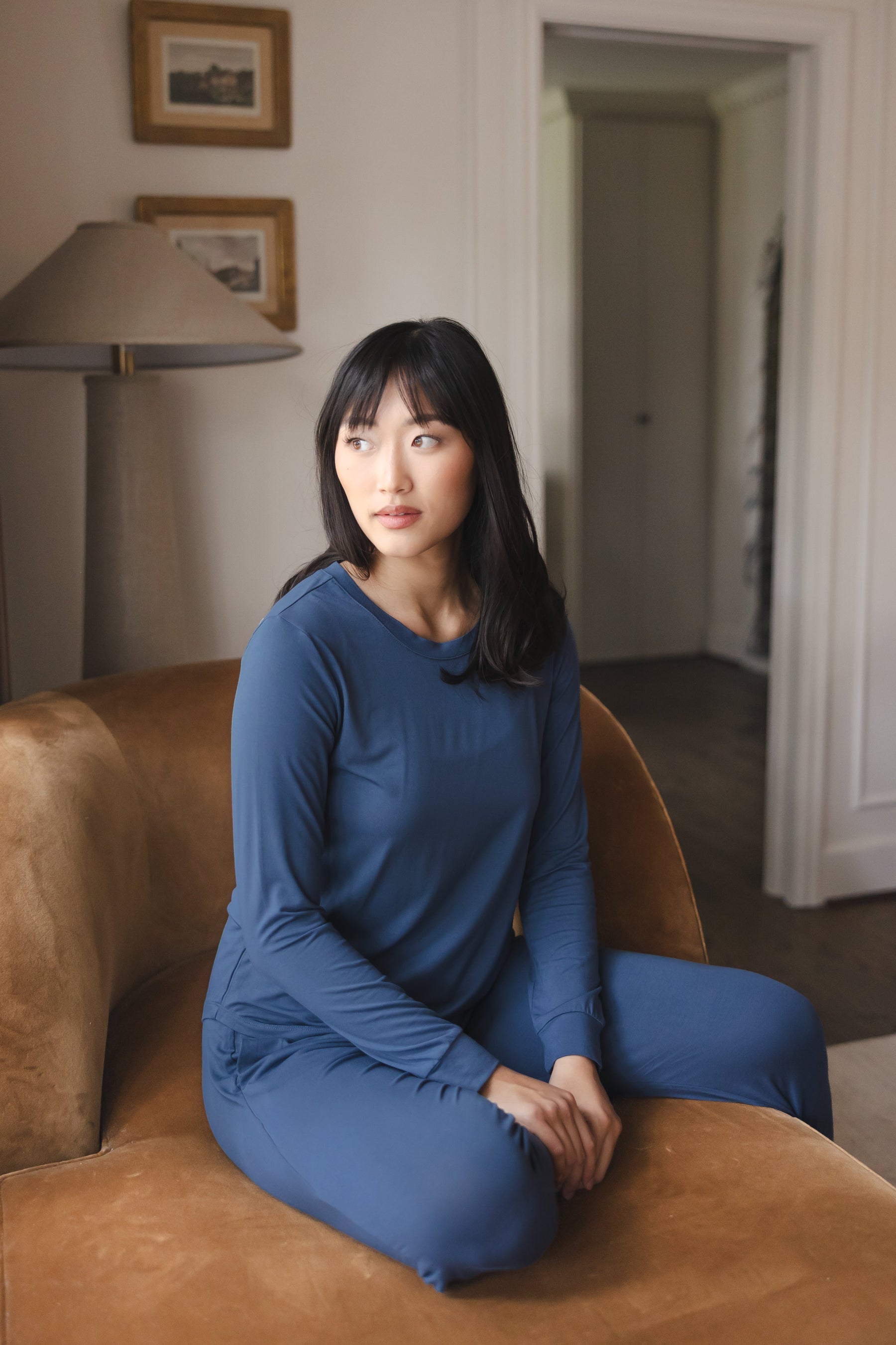Modal posing in Women's Jogger Pajama Set in Oxford sitting on a brown sofa