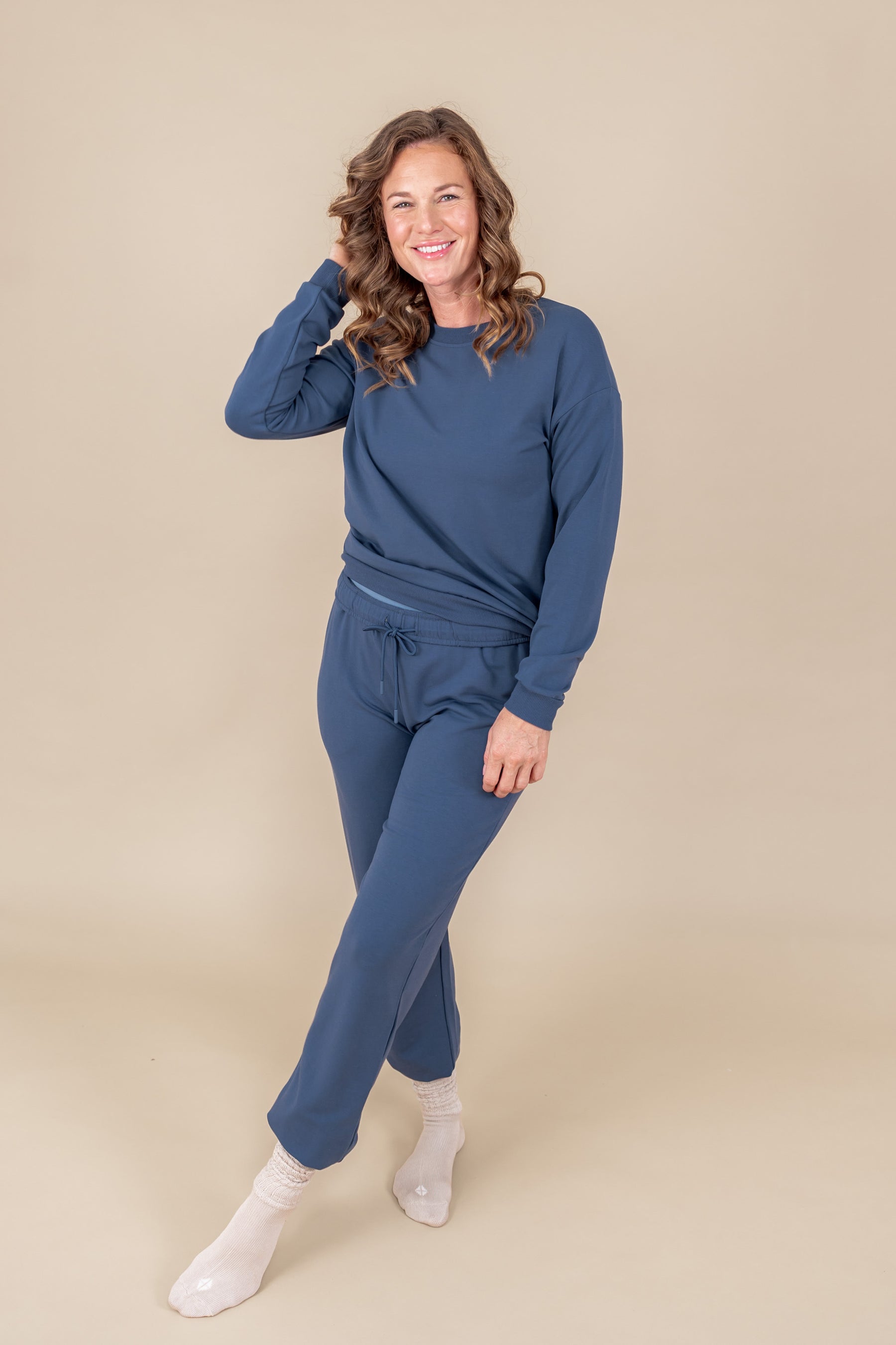 Modal wearing Women's Jogger Pants in Oxford color under a similar color sweatshirt on a beige background