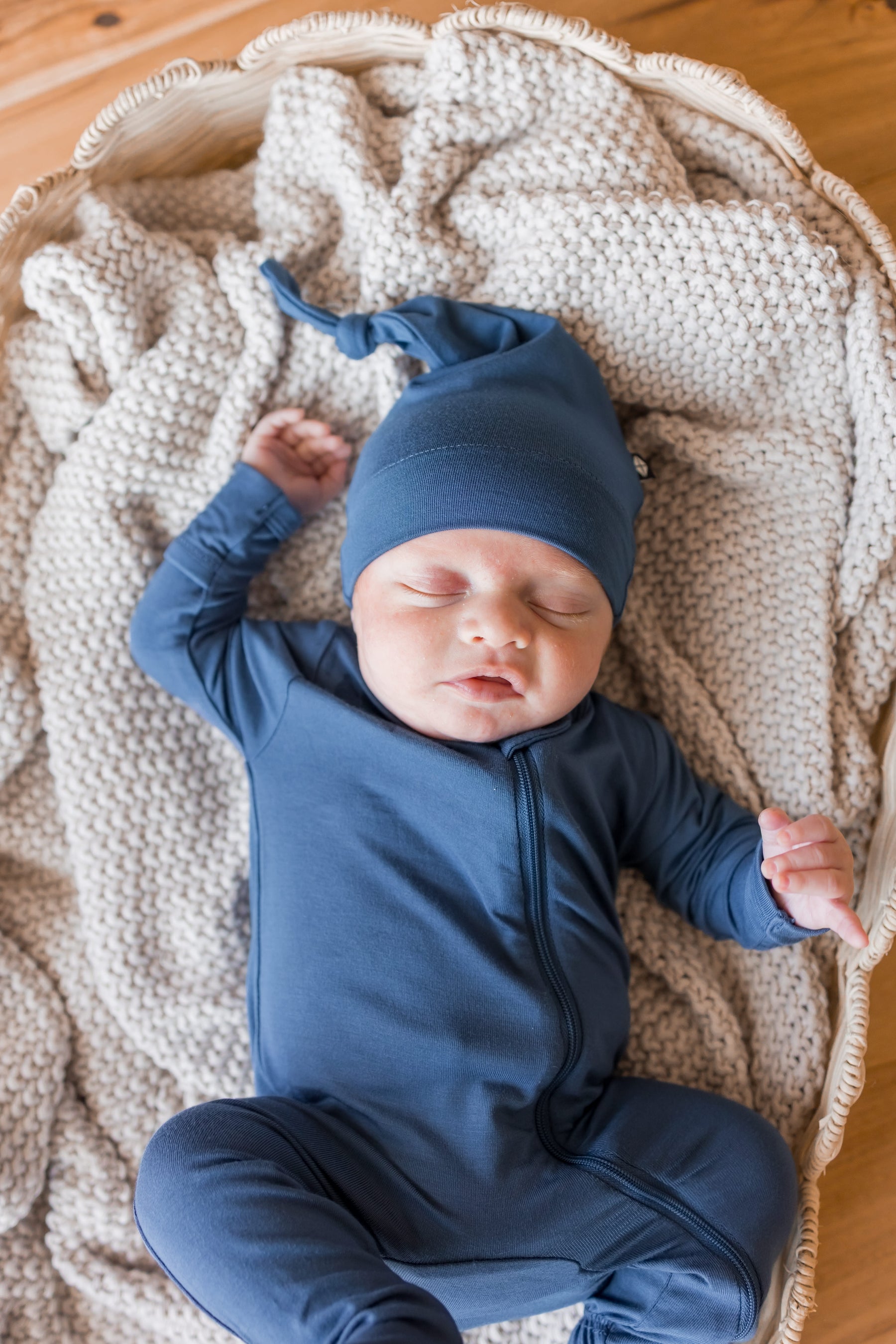 Baby sleeping in Knotted Cap in Oxford with zippered footie in Oxford