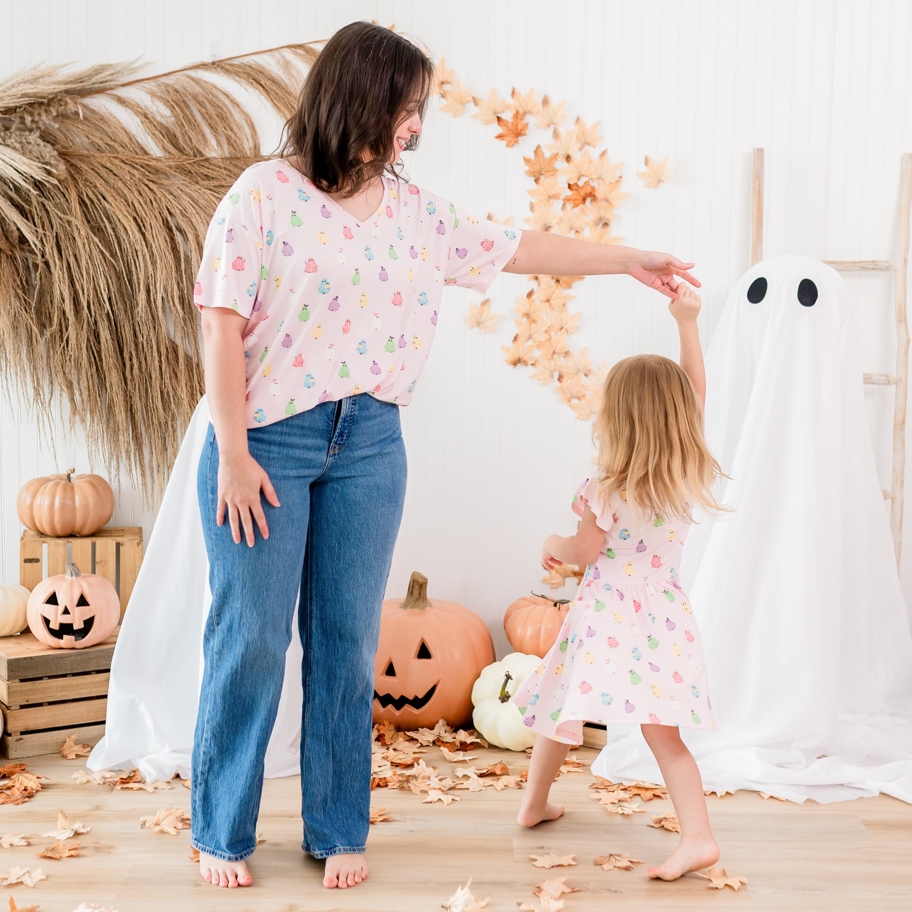 Mother and daughter matching in Pastel Ghost in front of a fall backdrop. Mother wearing the Women's Relaxed Fit V-Neck in Pastel Ghost twirling her daughter wearing the Pocket dress