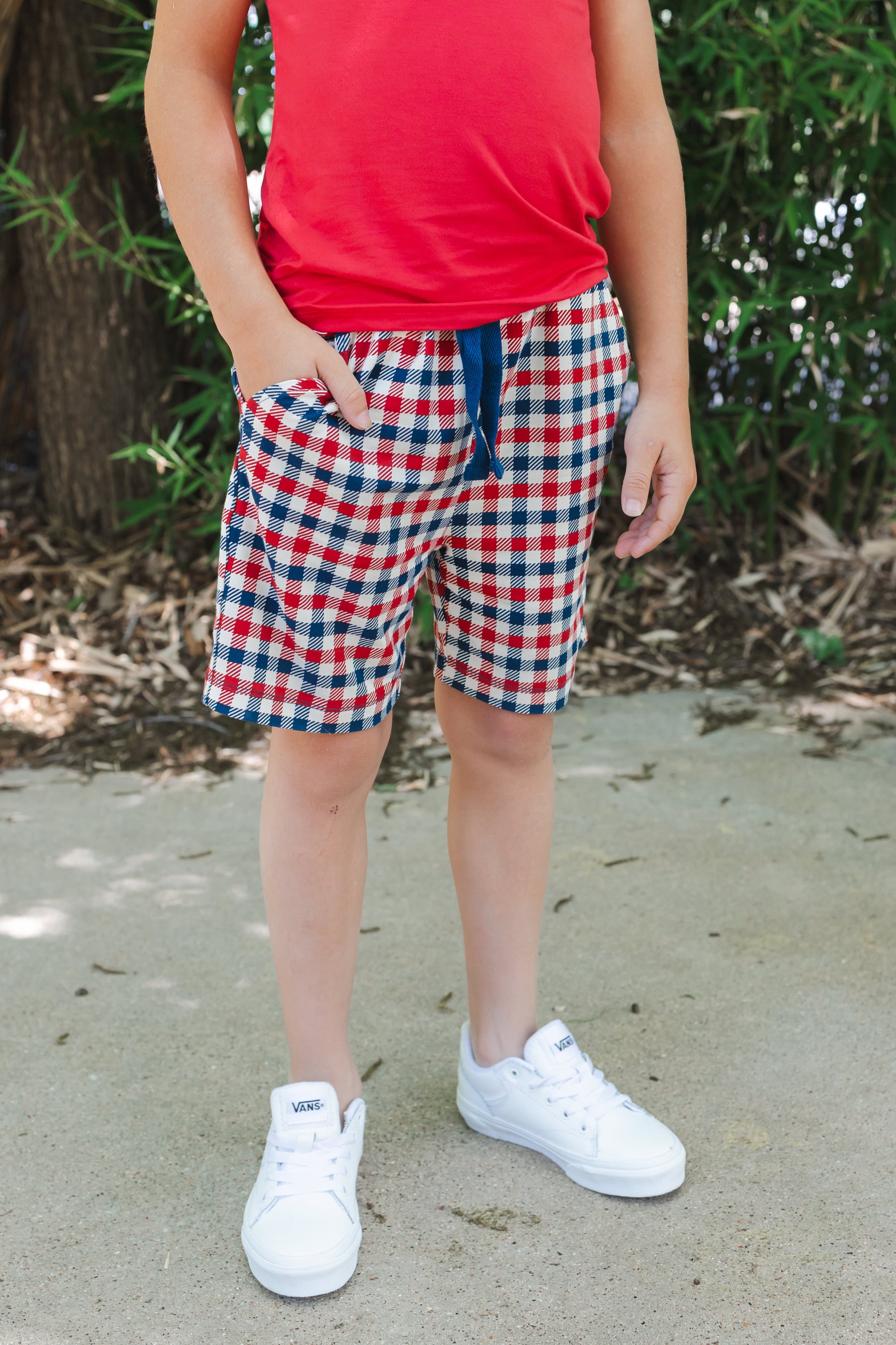 Drawstring shorts with pockets in red blue and white Patriotic Gingham check print over a red tank top and white shoes