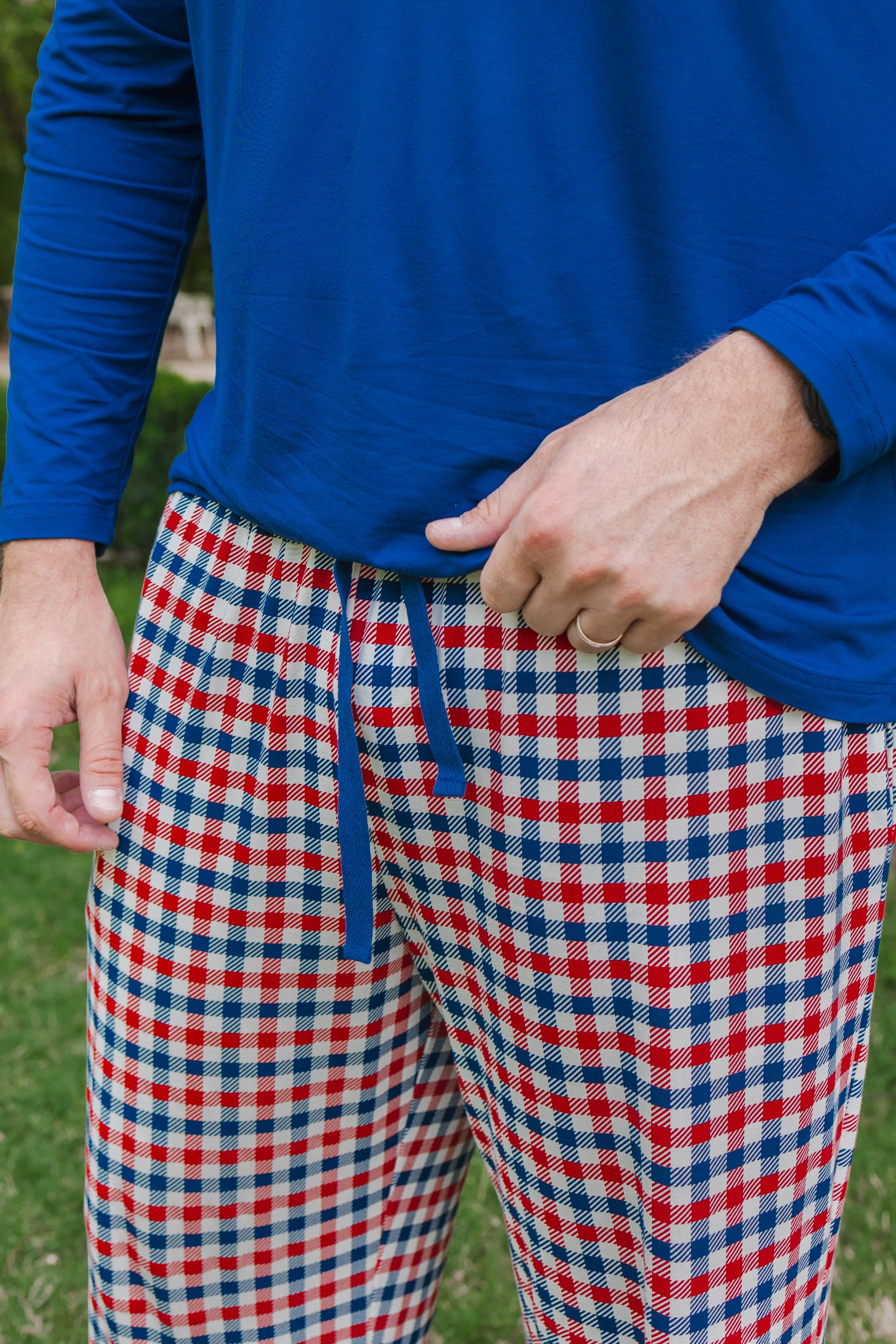 Model in Men's lounge pant with drawstrings in red blue and white patriotic gingham check print over a Men's Long Sleeve Henley Top in Tahoe