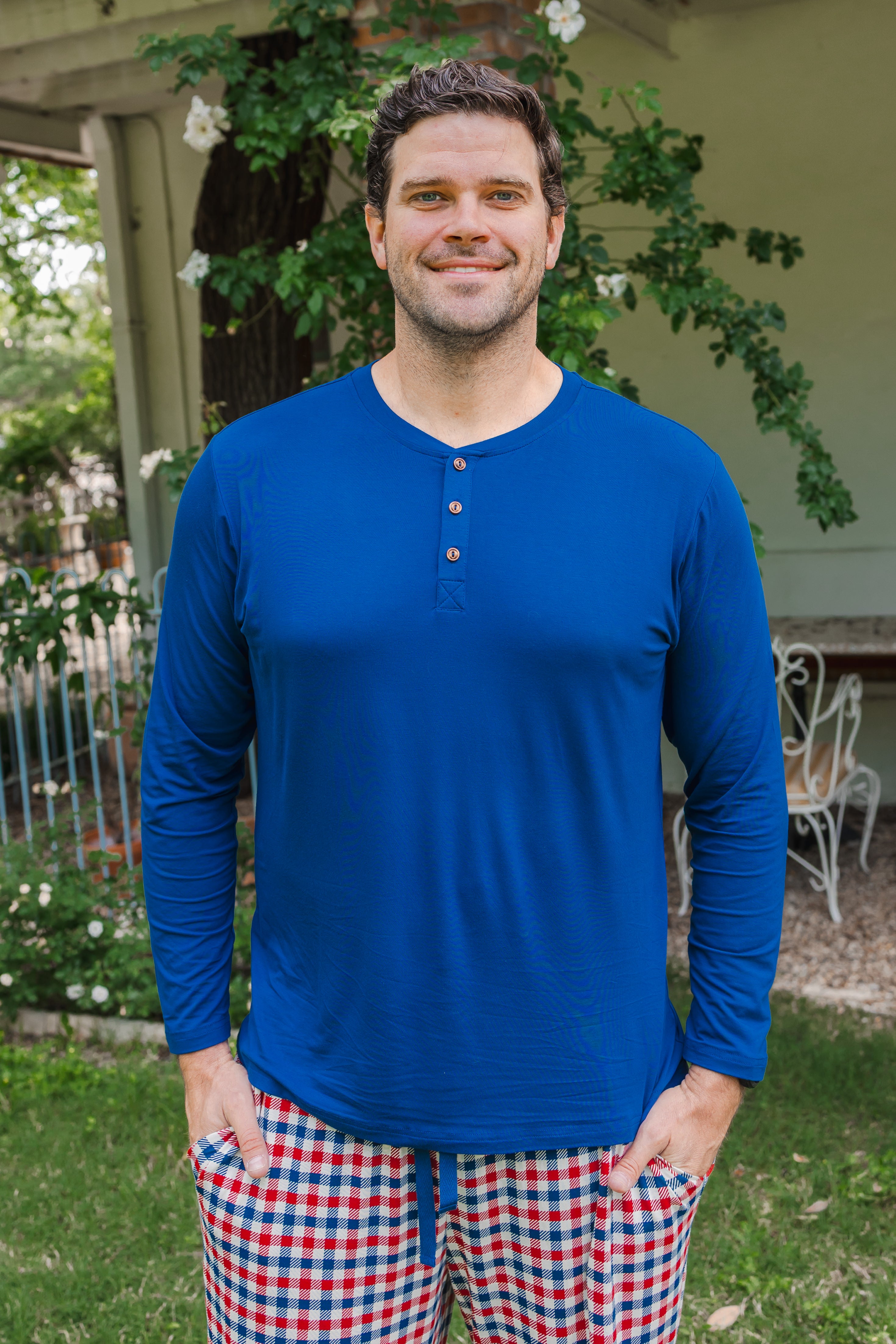 Man smiling outdoors wearing Men's Long Sleeve Henley Top in Tahoe over a red blue and white Patriotic Gingham check print Men's lounge pant