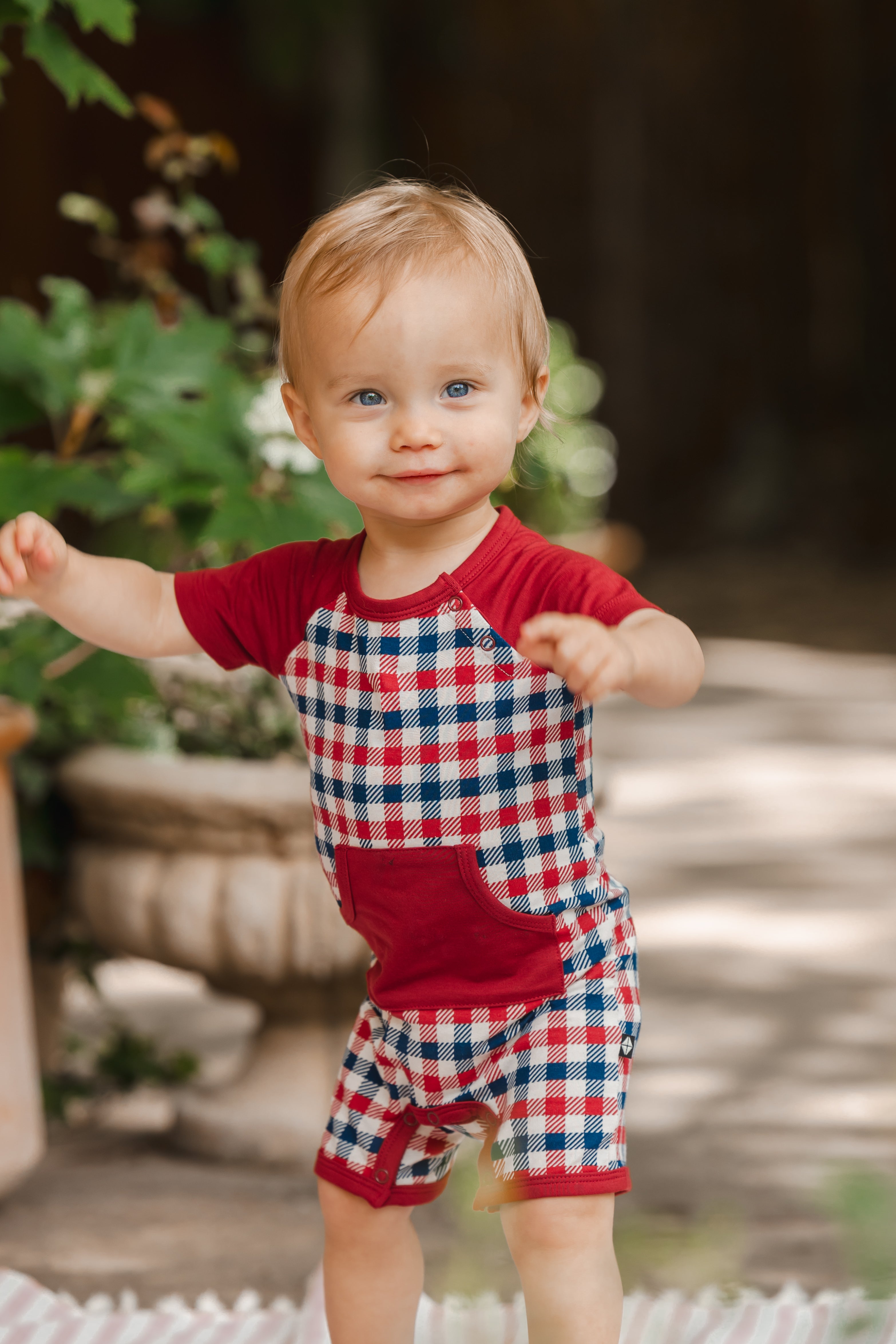 Child posing outdoors in red blue and white Patriotic Gingham check print shortall 