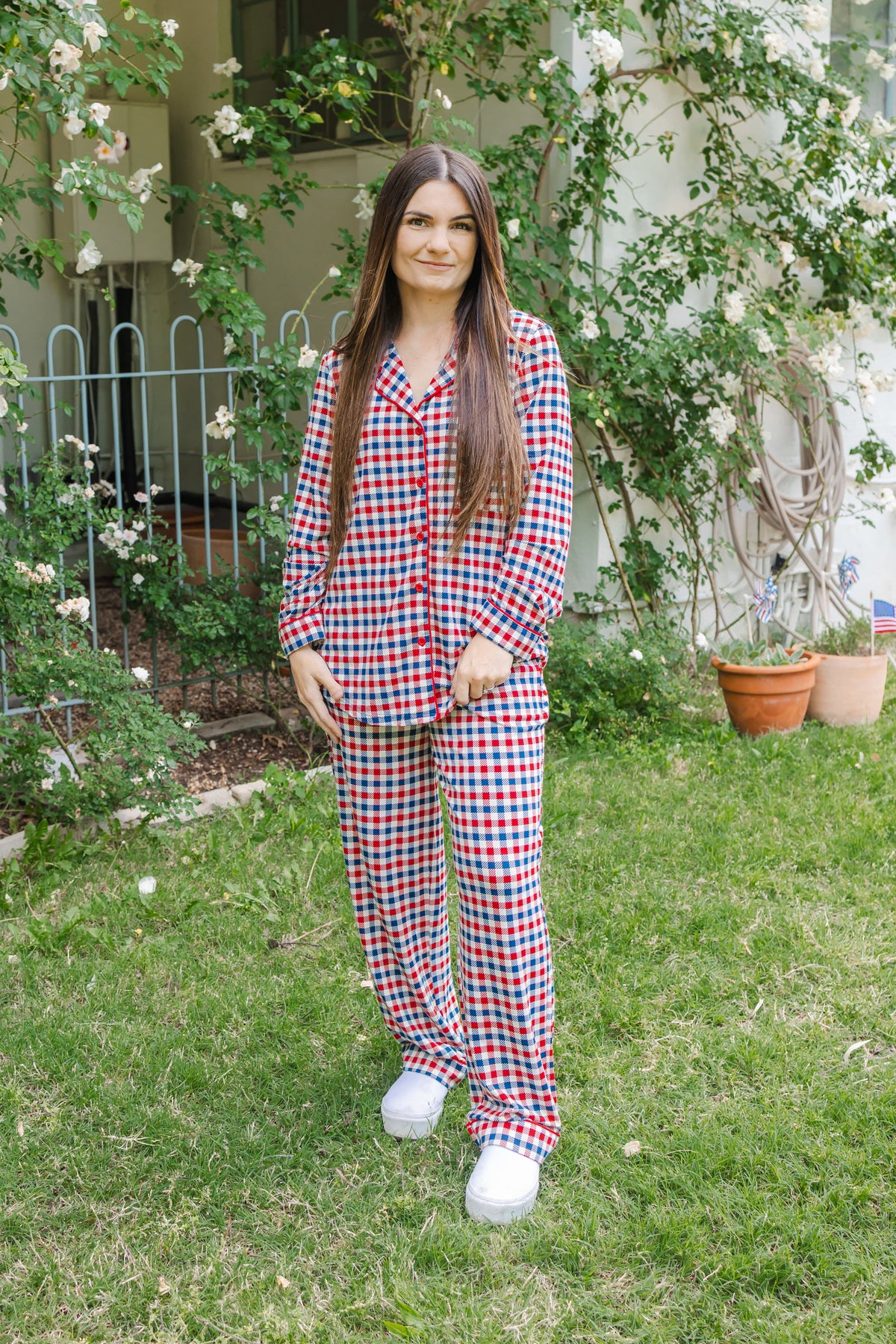 Woman wearing a red white and blue Patriotic Gingham check print long sleeve pajama set outdoors