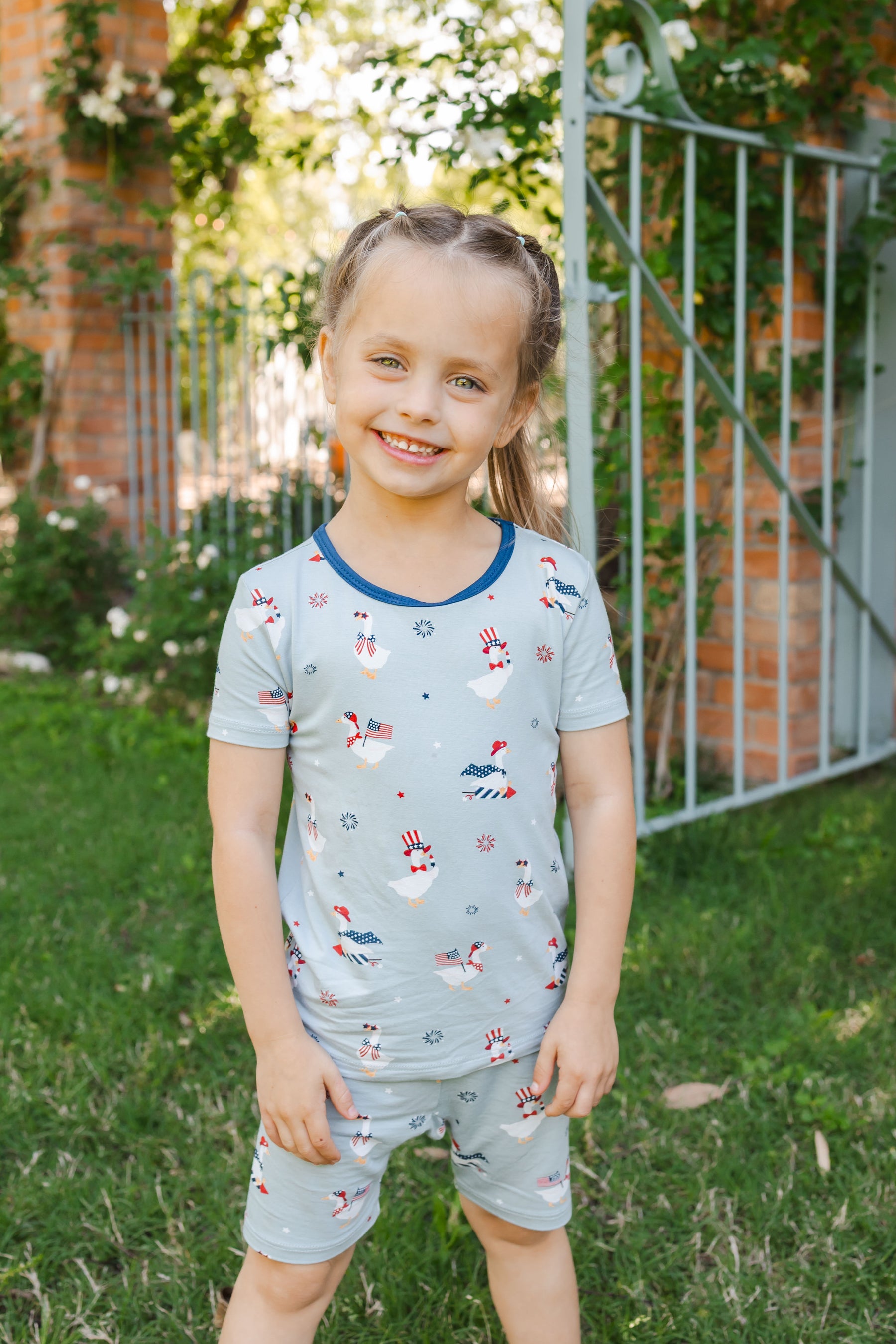 Child wearing light blue Short Sleeve Pajamas in Patriotic Goose print outdoors