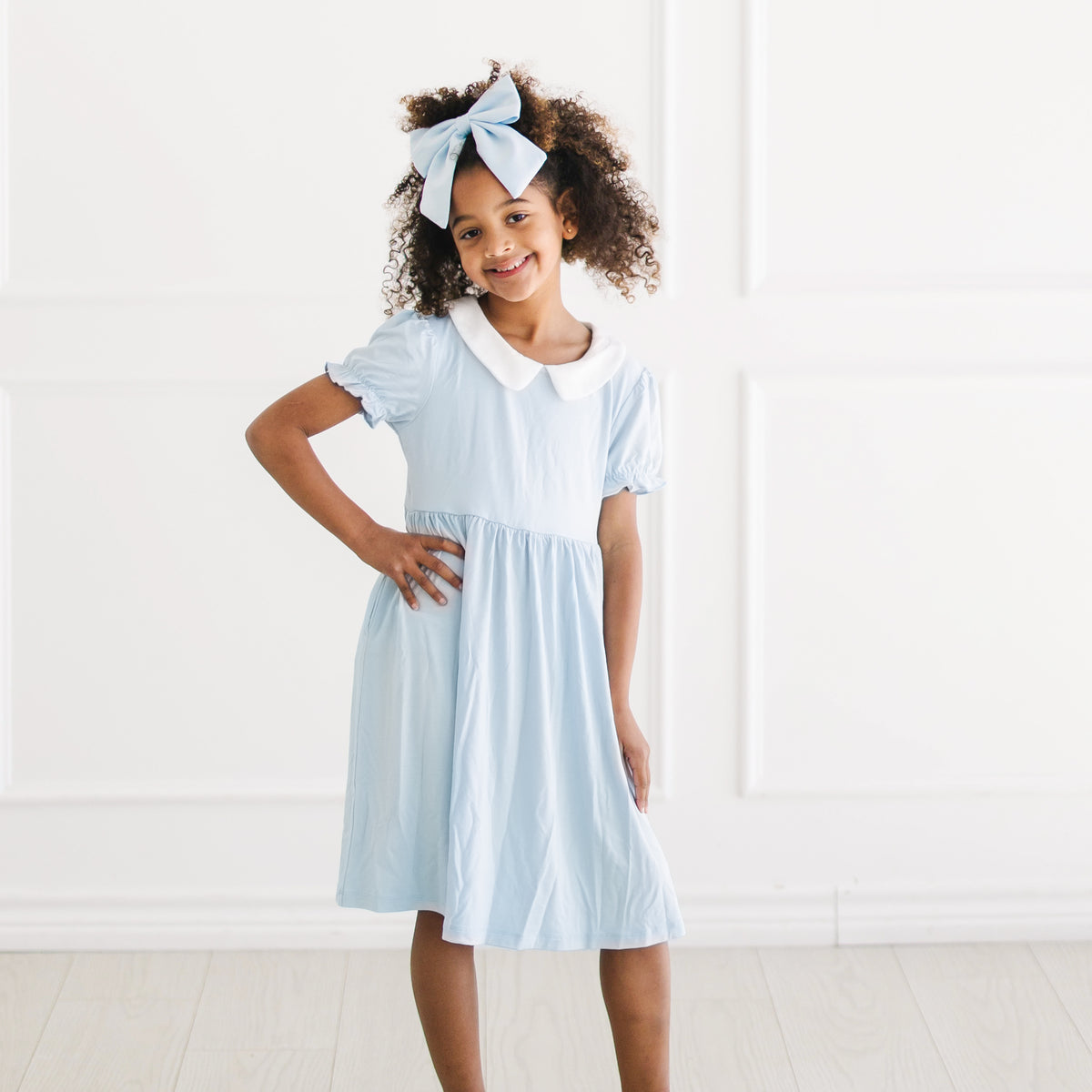 Young girl posing wearing the Peter Pan Collar Dress in Breeze
