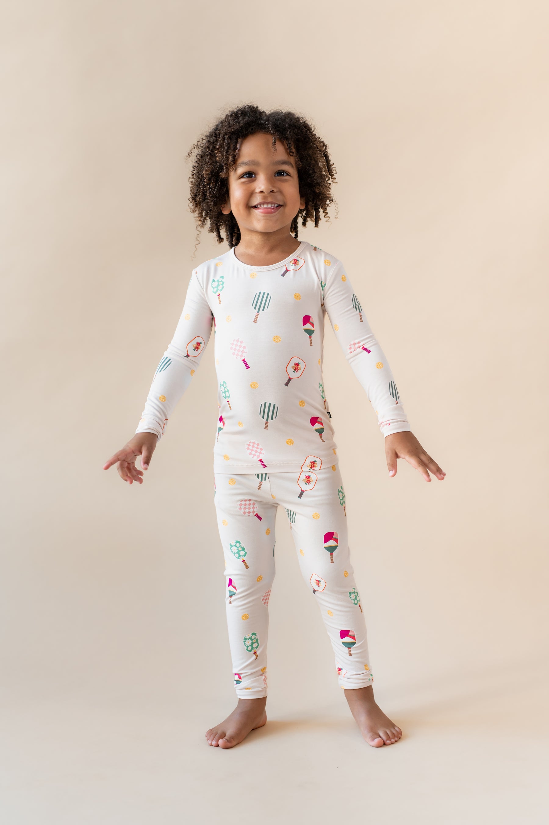 Girl posing in Long Sleeve Pajamas in Pickleball print standing on pickleball court