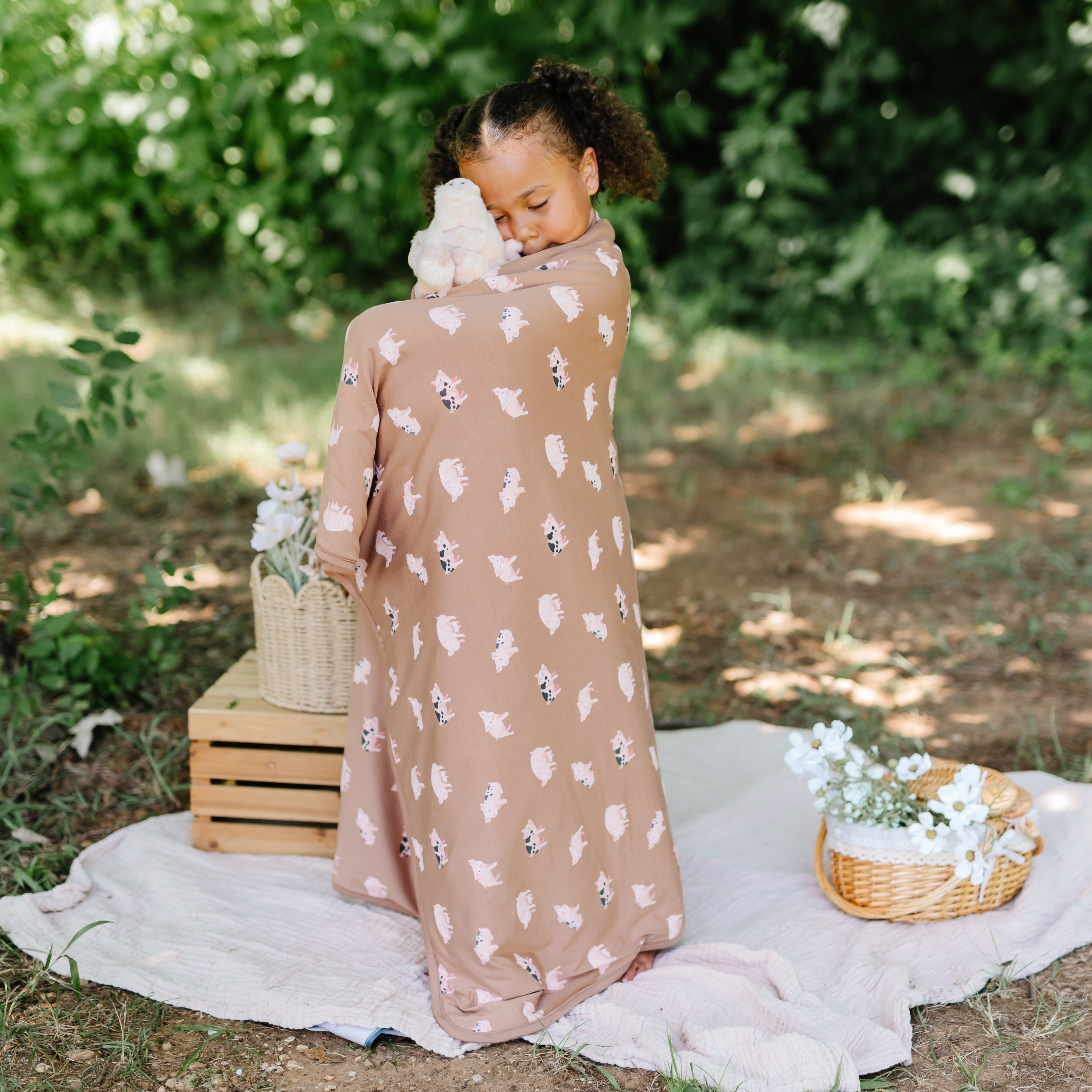 Child wrapped in TOG 1.0 Toddler Pig Blanket
