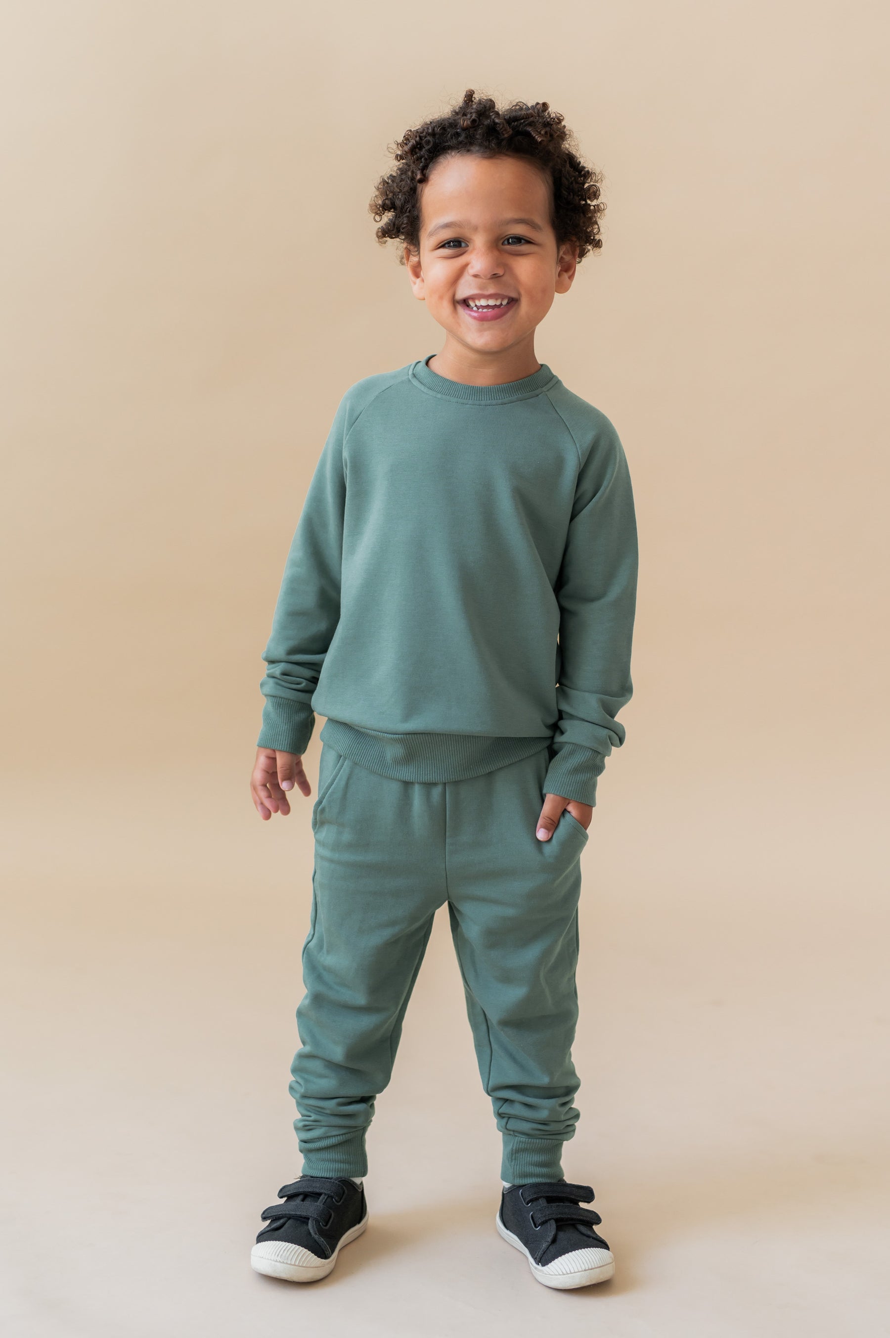 Boy wearing Long Sleeve Jogger Set in Pine color on a beige background