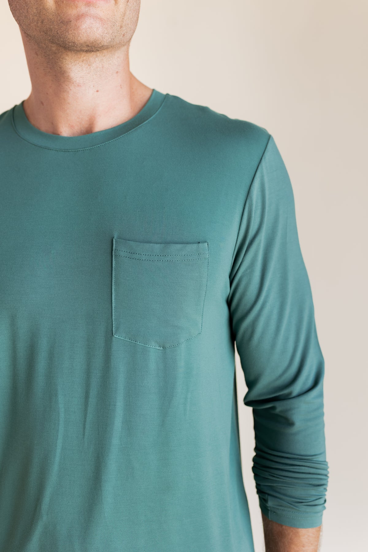 Model showcasing Men's Jogger Set shirt in Pine with pocket on a beige background
