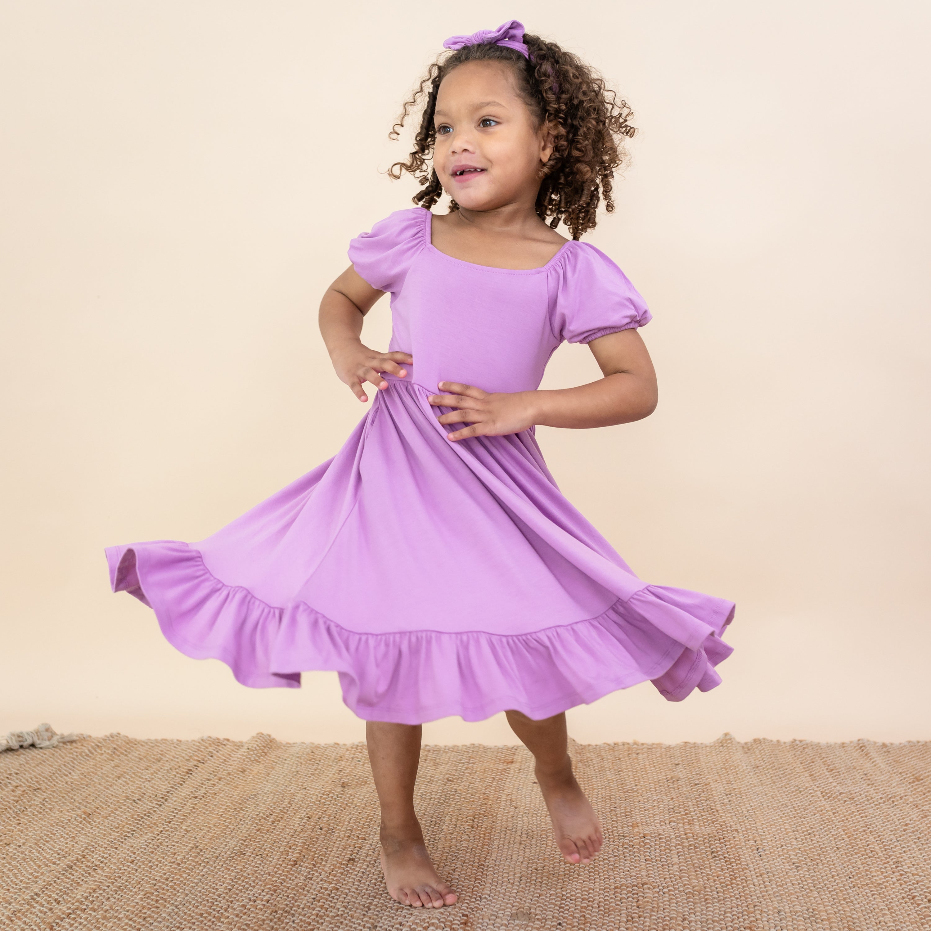 Toddler twirling in Puff Sleeve Twirl Dress in Poi