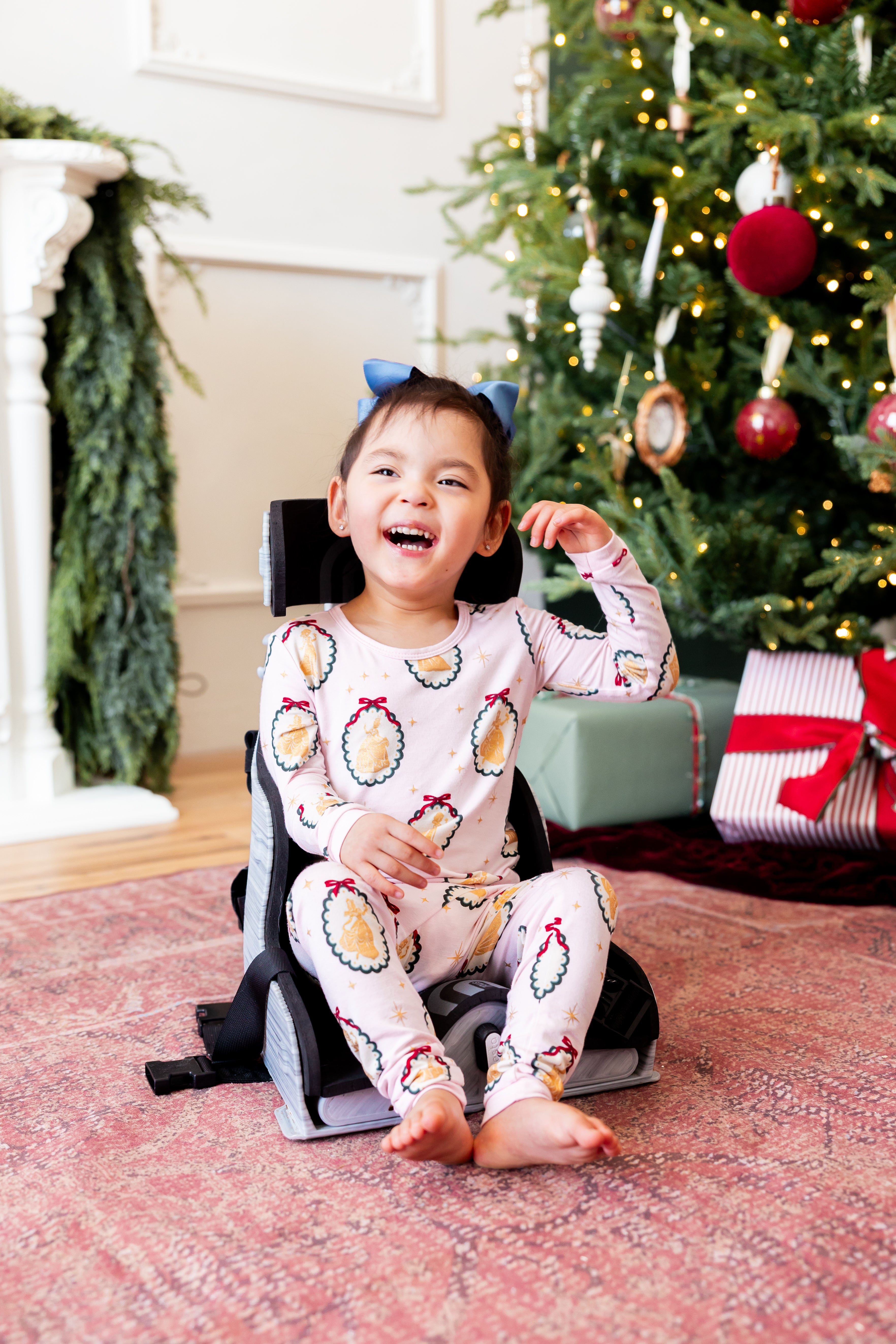 Girl wearing Long Sleeve Pajamas in Princess Holiday Portraits print smiing in front of Christmas tree