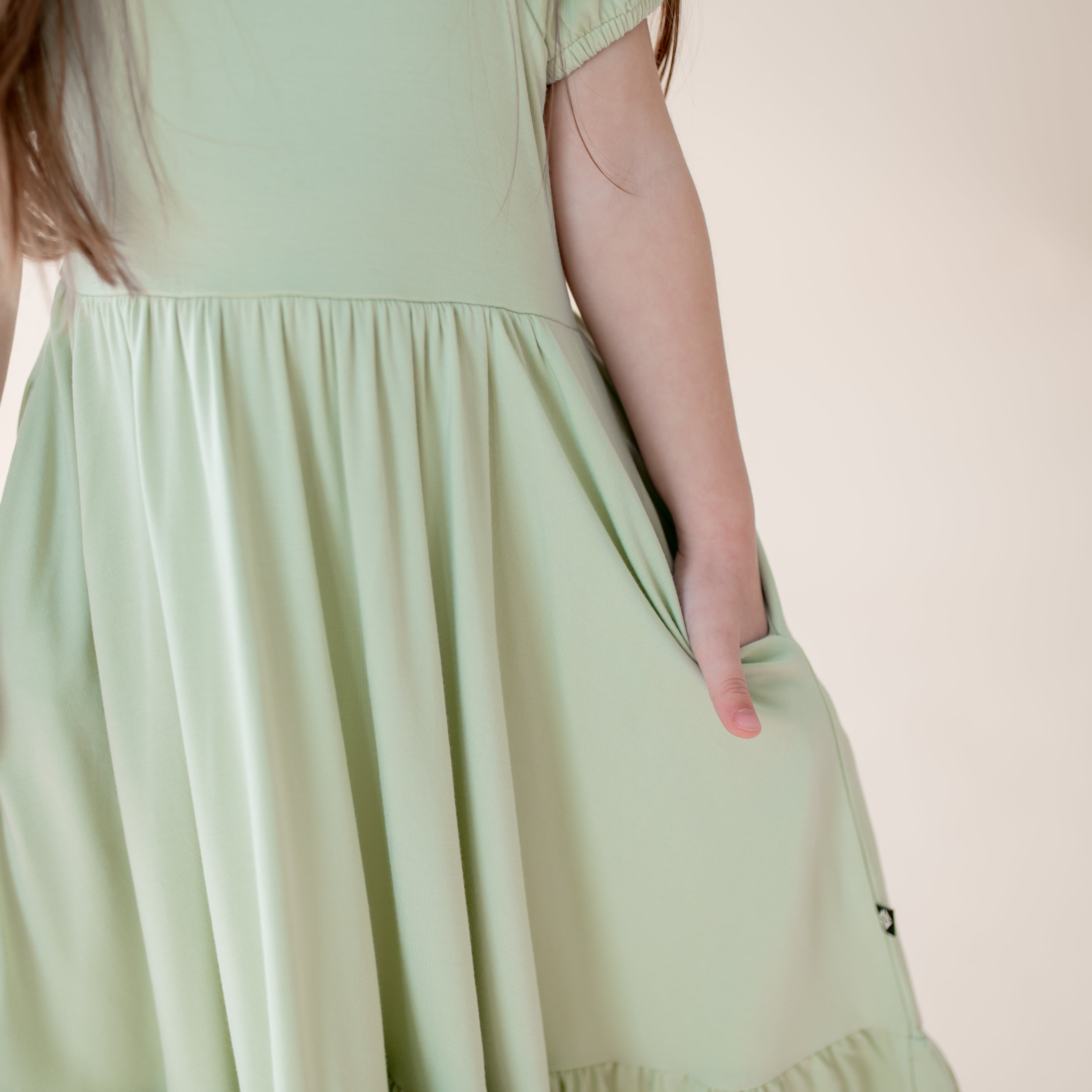 Light green dress worn by a person on a plain background