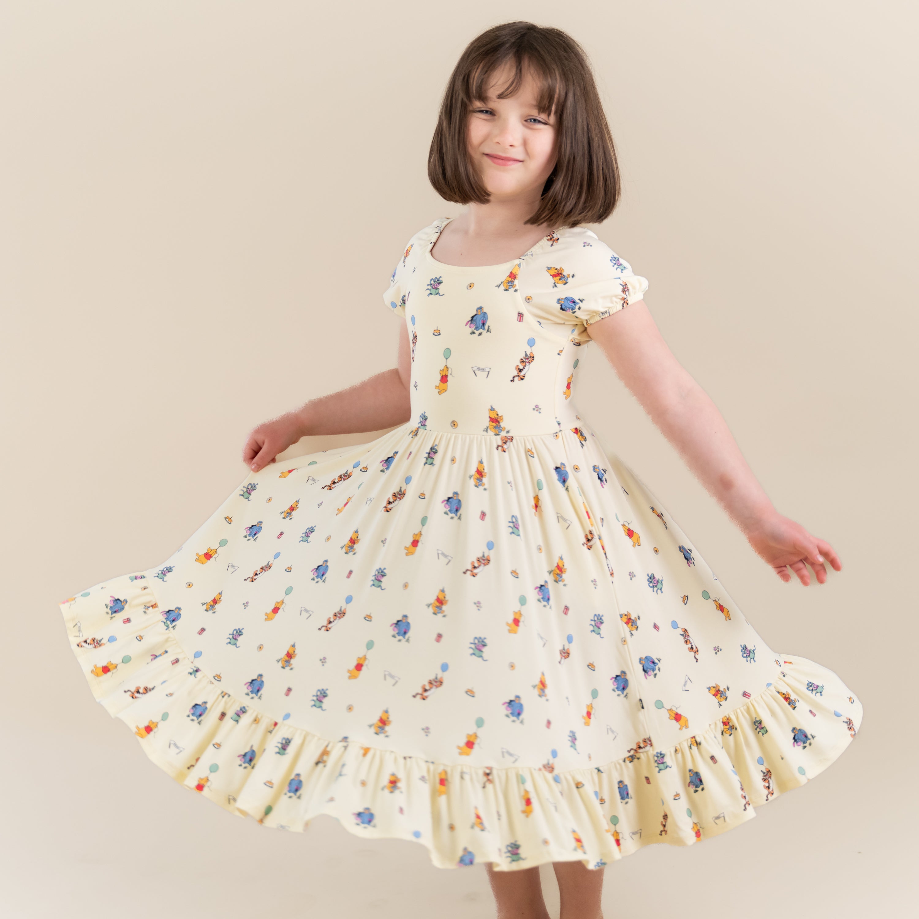 Young girl twirling wearing the Puff Sleeve Twirl Dress in Winnie the Pooh Celebration