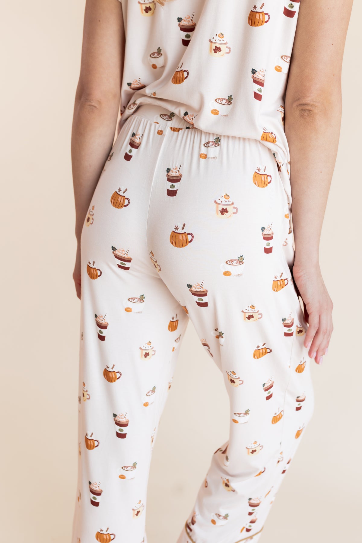 Modal showcasing the backside of pajamas of Women's Short Sleeve Cropped Pajama Set with Pumpkin Spice Latte print on a beige background