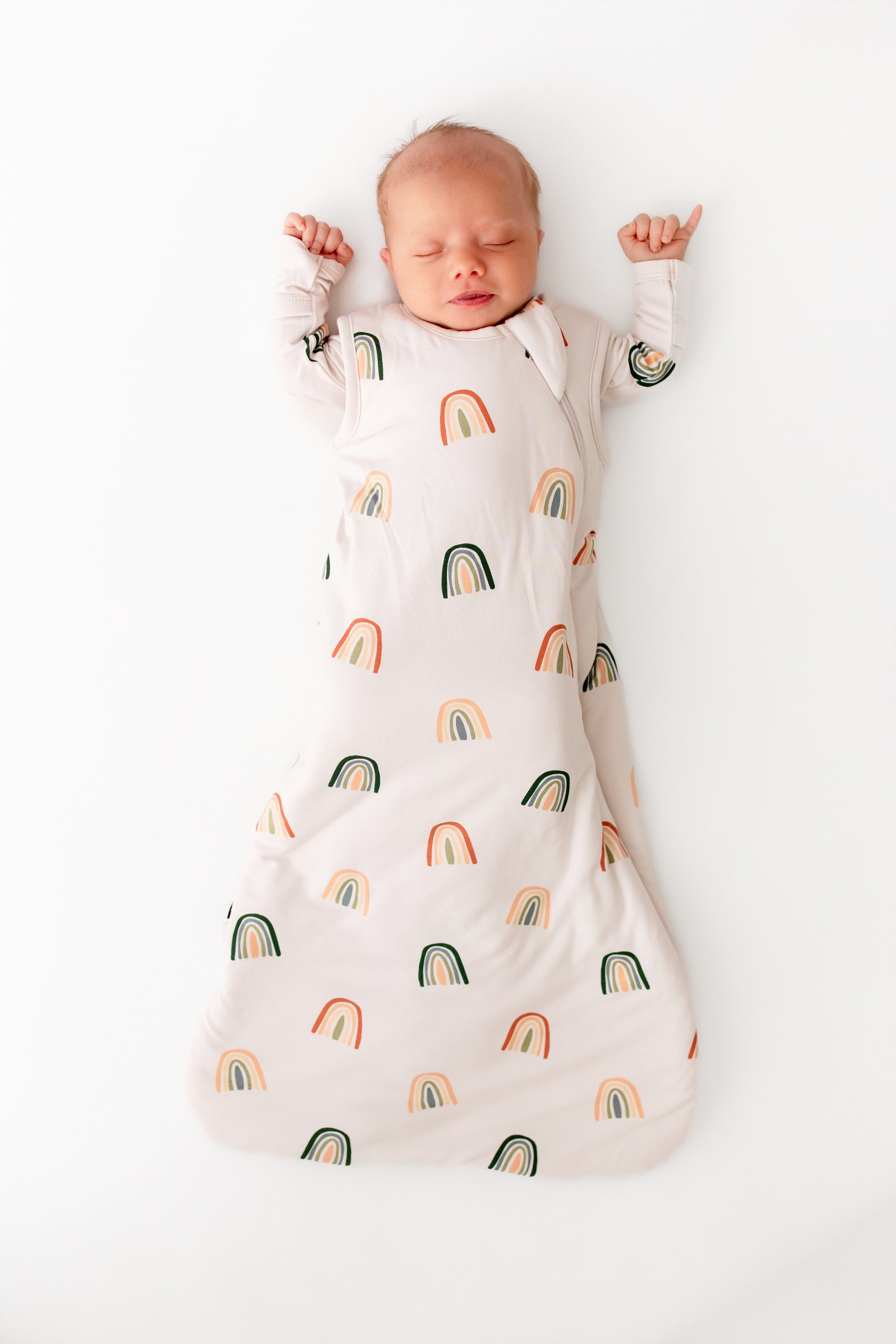 Baby sleeping in Sleep Bag in Retro Rainbow 1.0 print on a white background