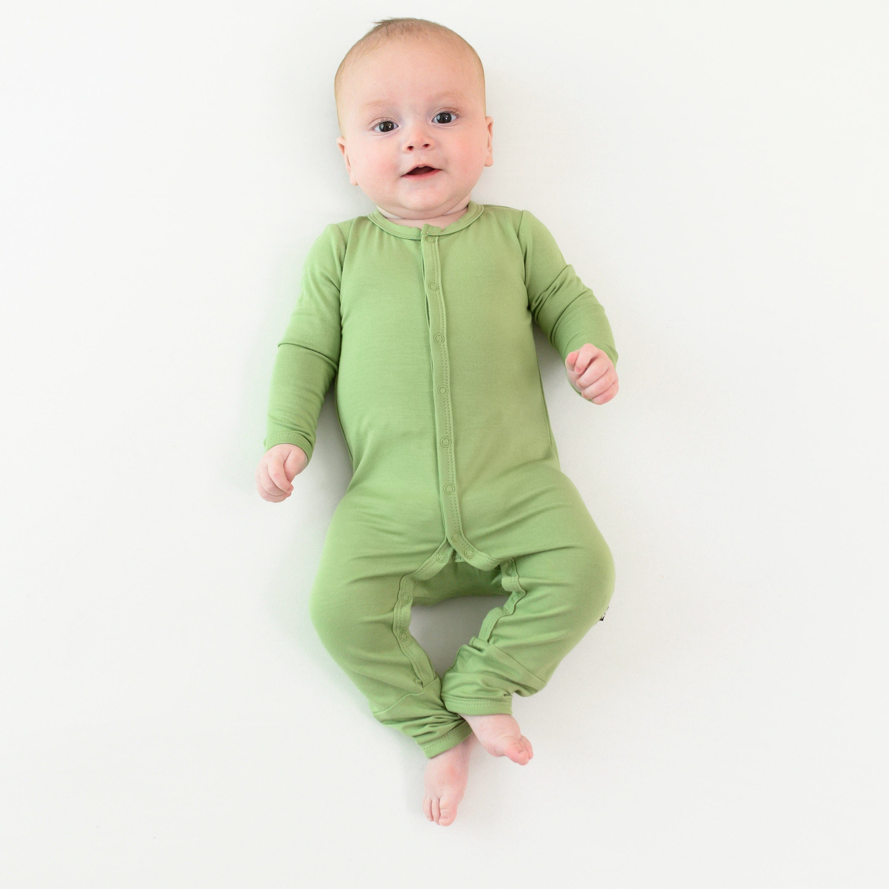 baby wearing snap romper in honu 