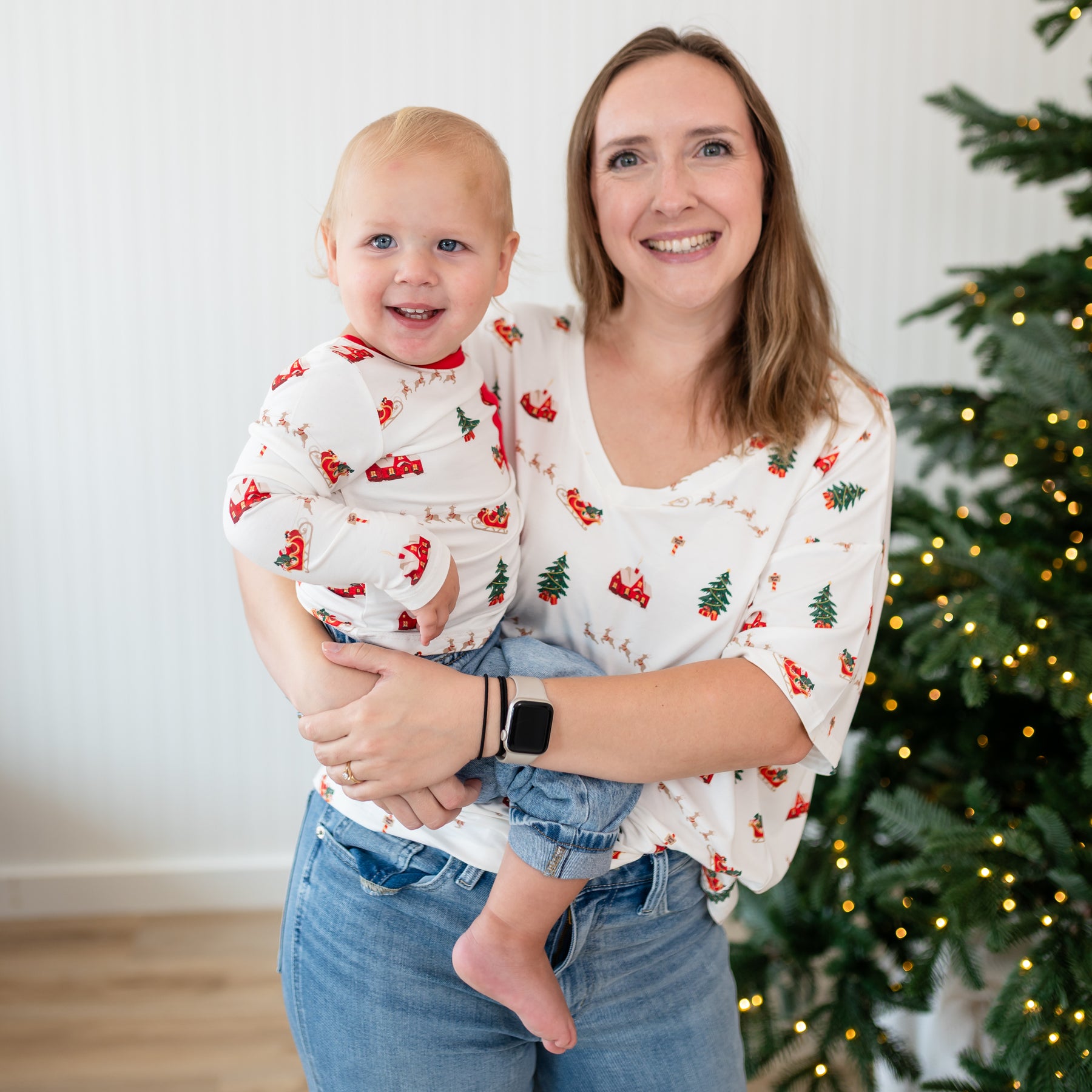 Female model wearing the Women's V-neck paired with jeans holding her child who is matching in a long sleeve crew neck