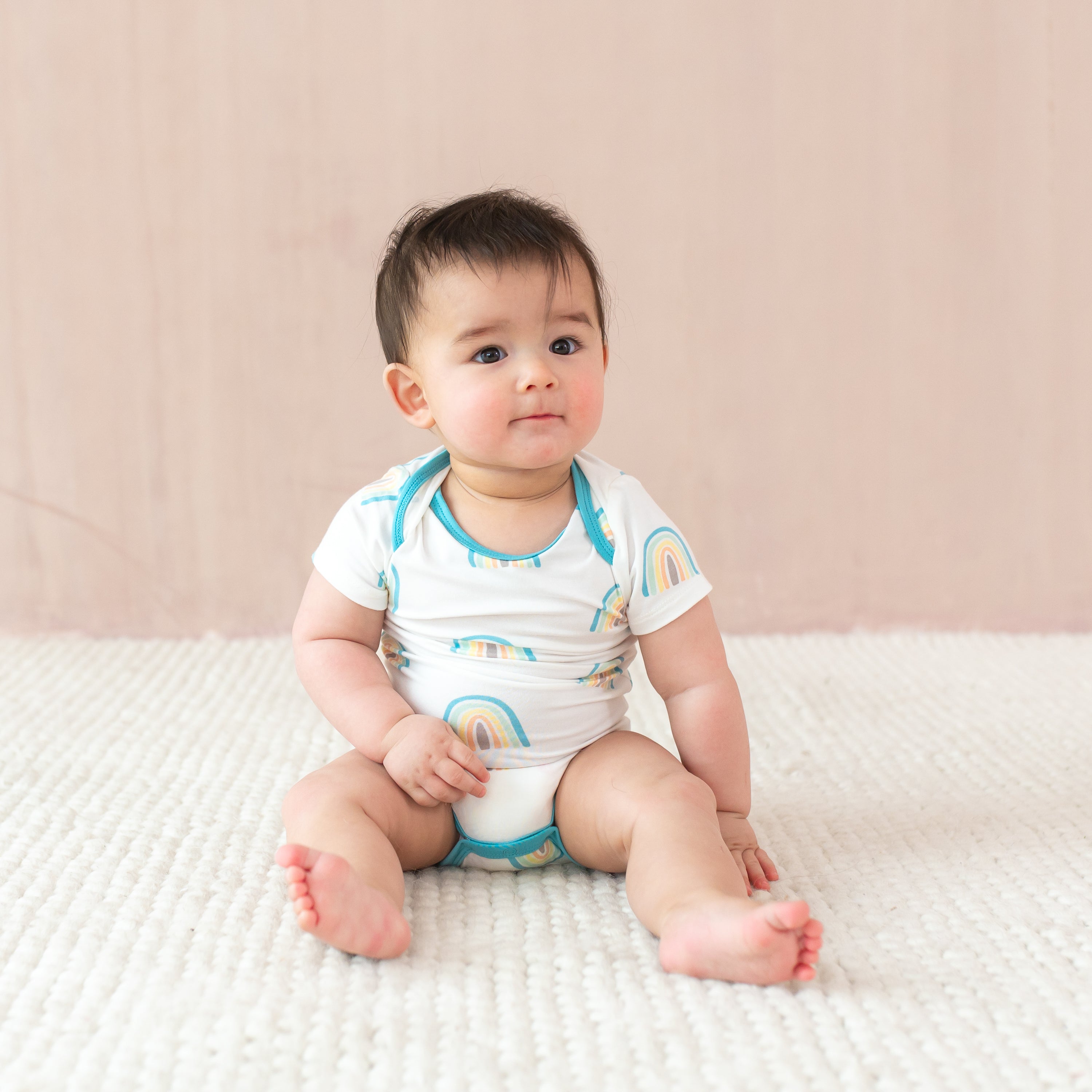 Baby sitting wearing Bodysuit in Makai Rainbow