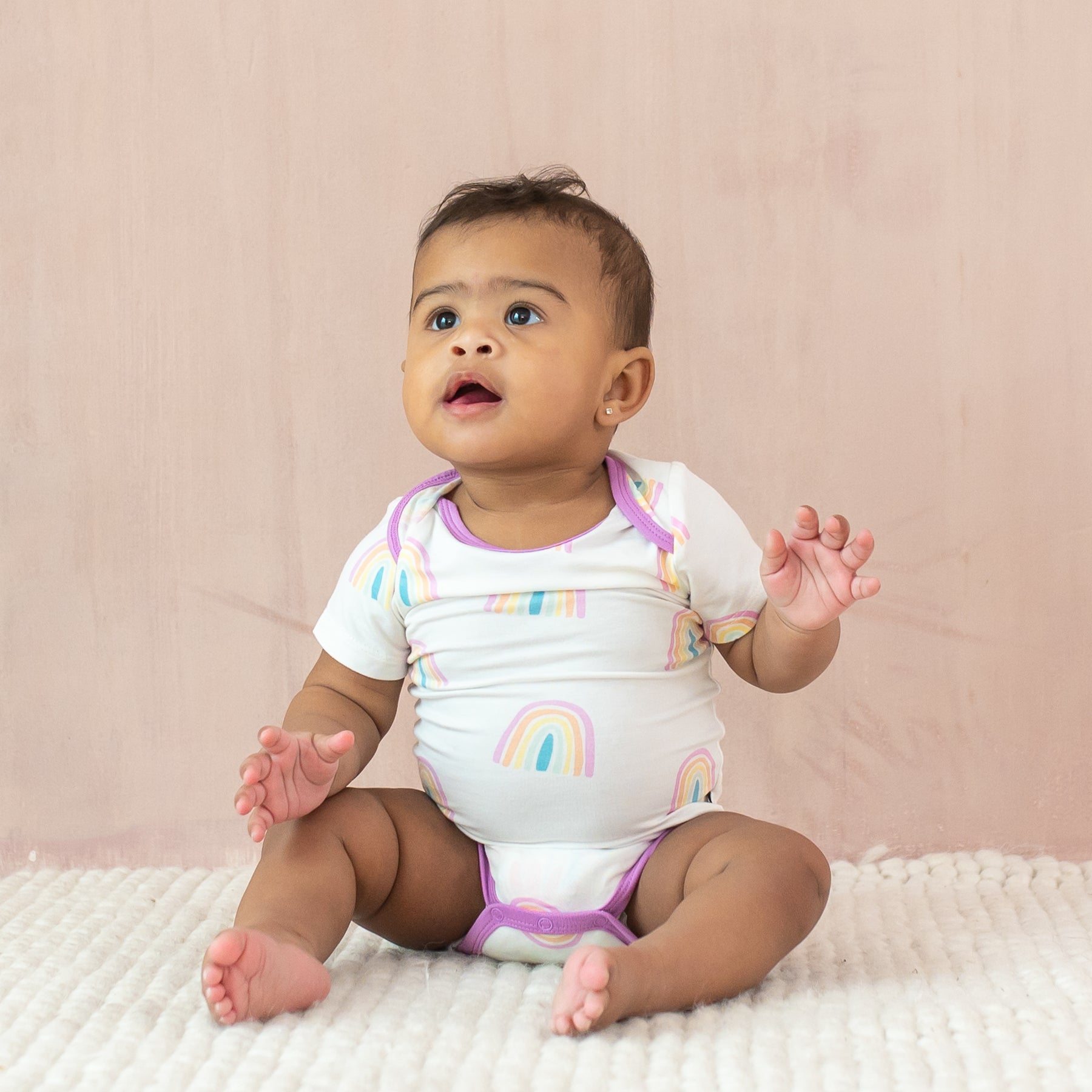 Baby sitting wearing Bodysuit in Poi Rainbow