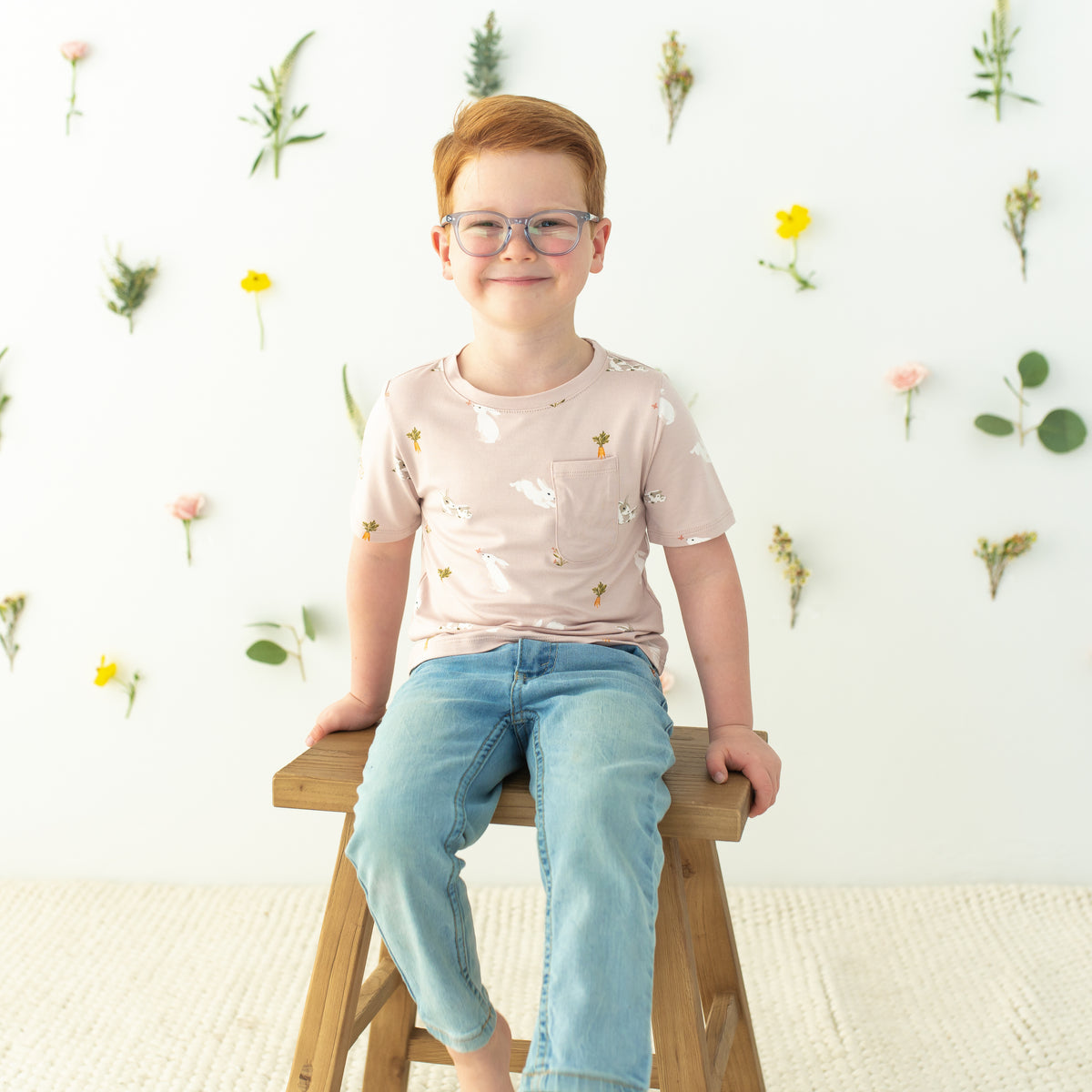 Toddler sitting on stool modeling Toddler Crew Neck Tee in Blush Rabbit