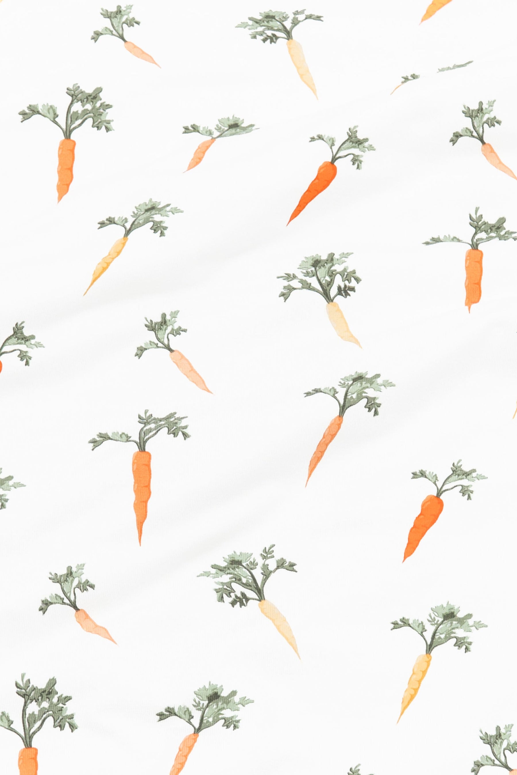 Close up of the fabric of the Carrot print showing the yellow and orange carrots with green stems on a white background