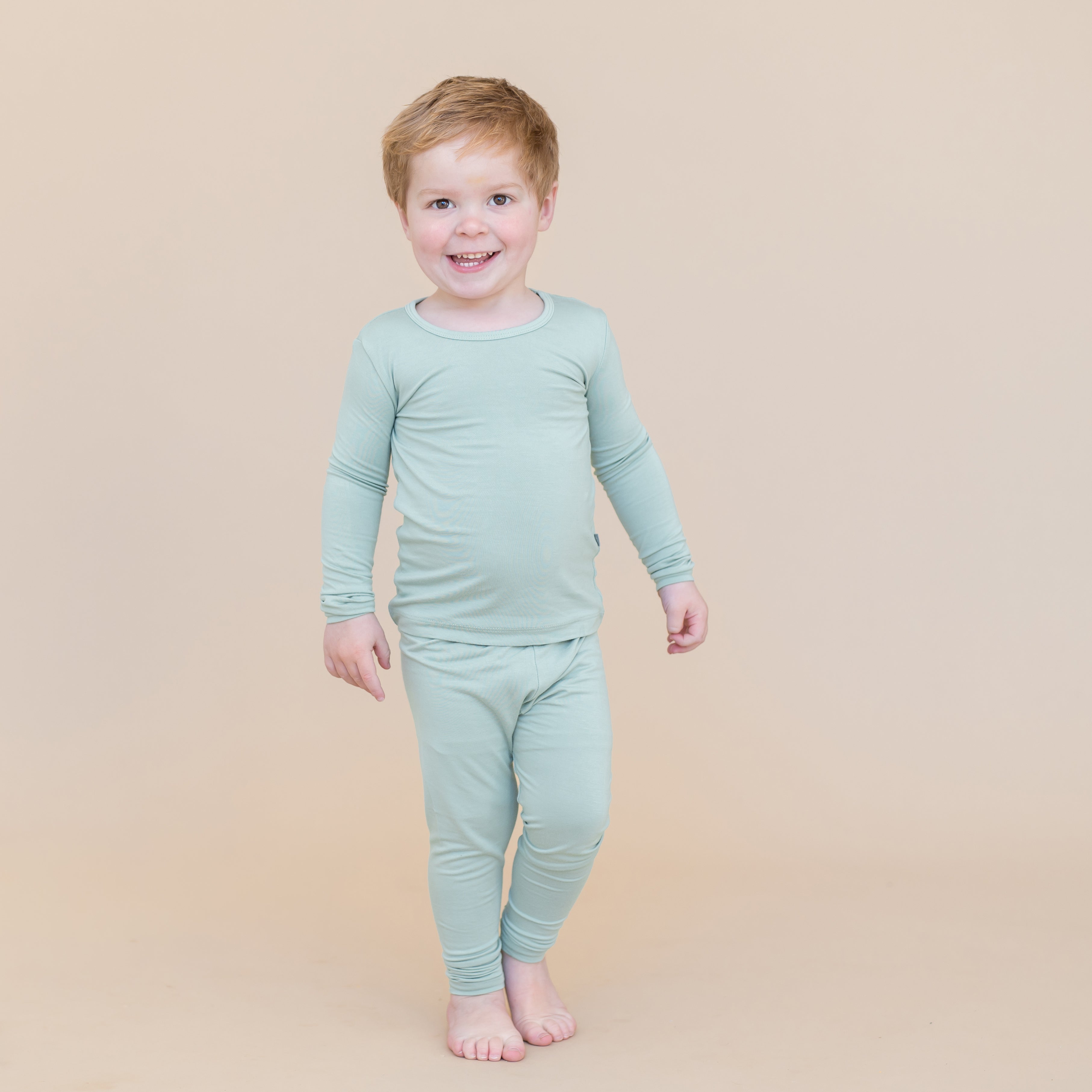 Toddler boy wearing sage green pajamas 