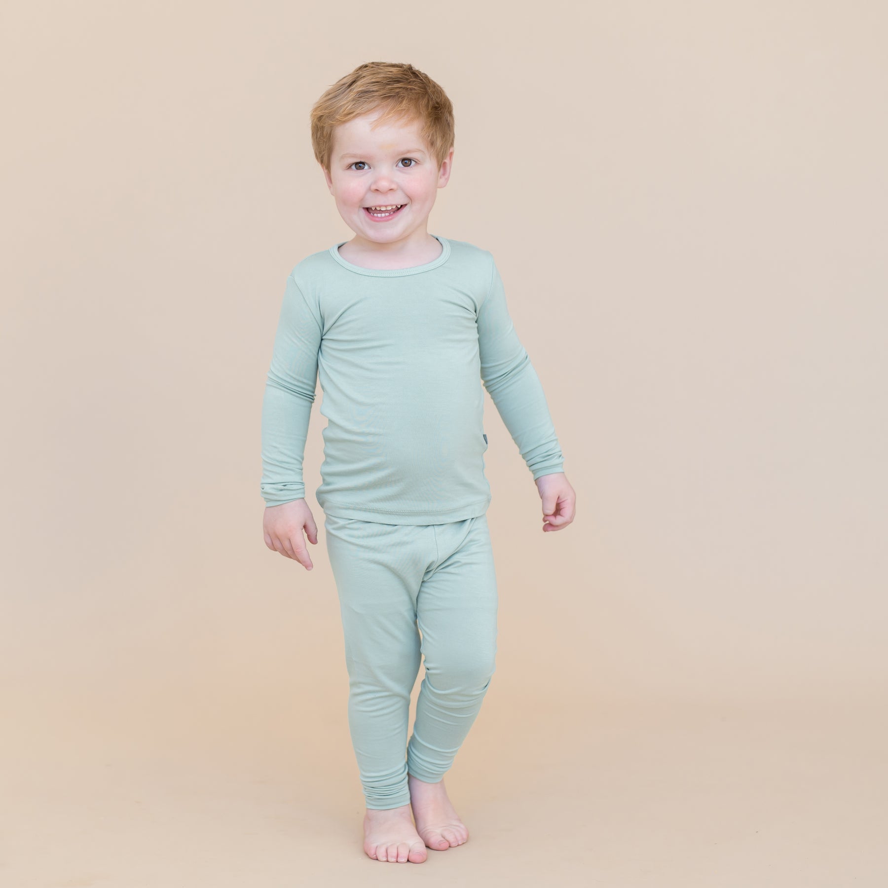 Toddler boy wearing sage green pajamas 