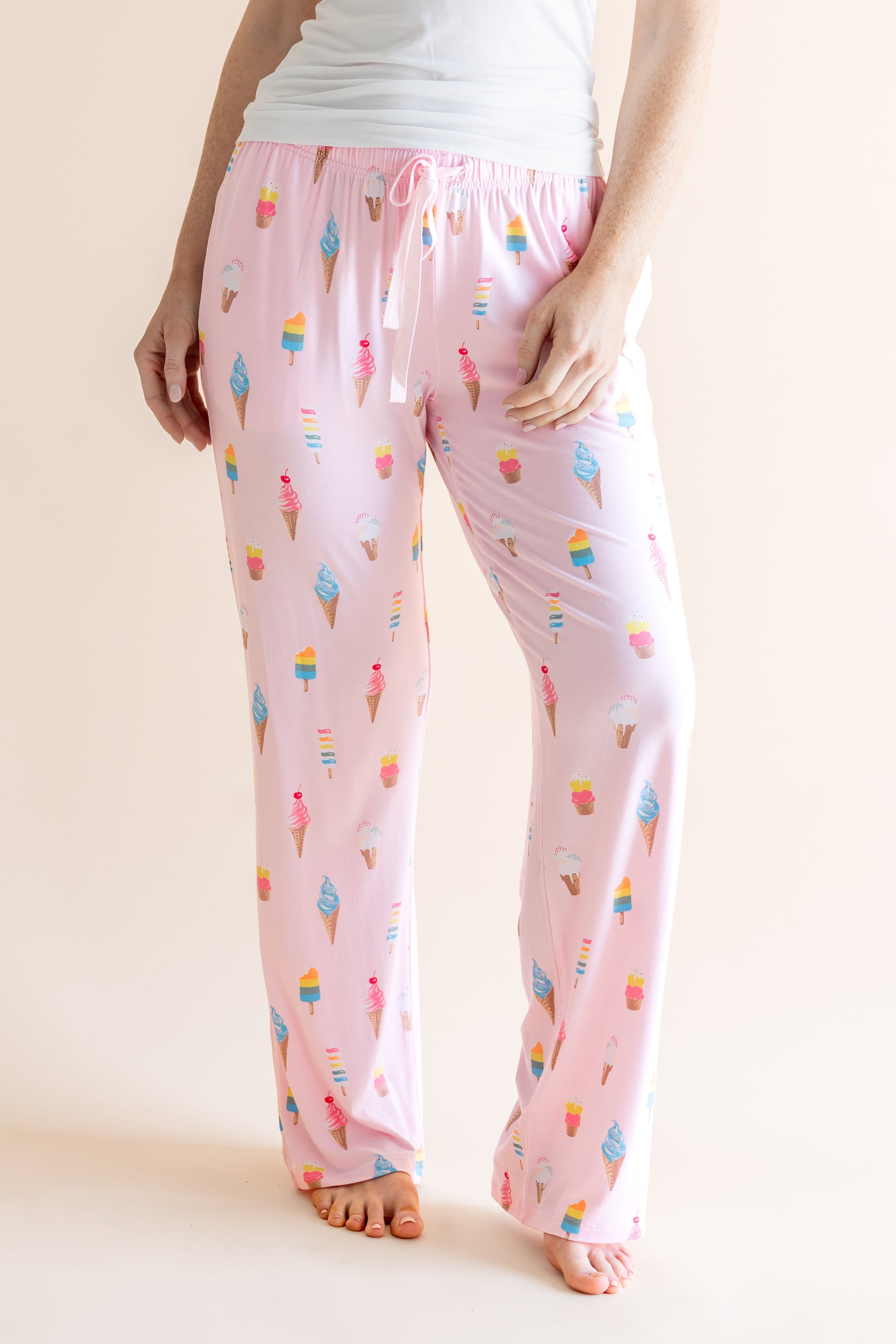 Model in Pink Women's Lounge Pants in Ice Cream print with drawstring under white camisole on beige background