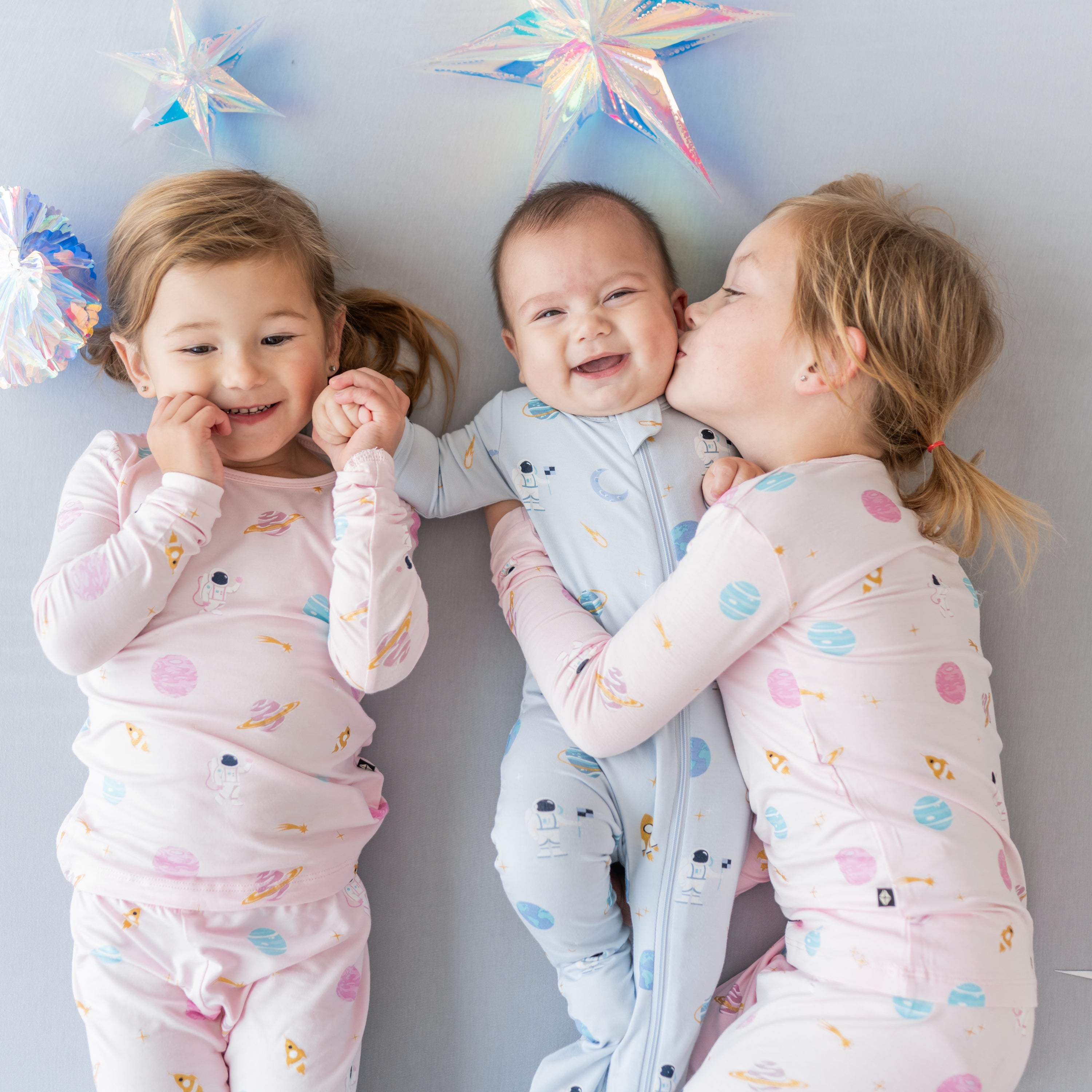 group of siblings wearing ice and sakura space pajamas and footie