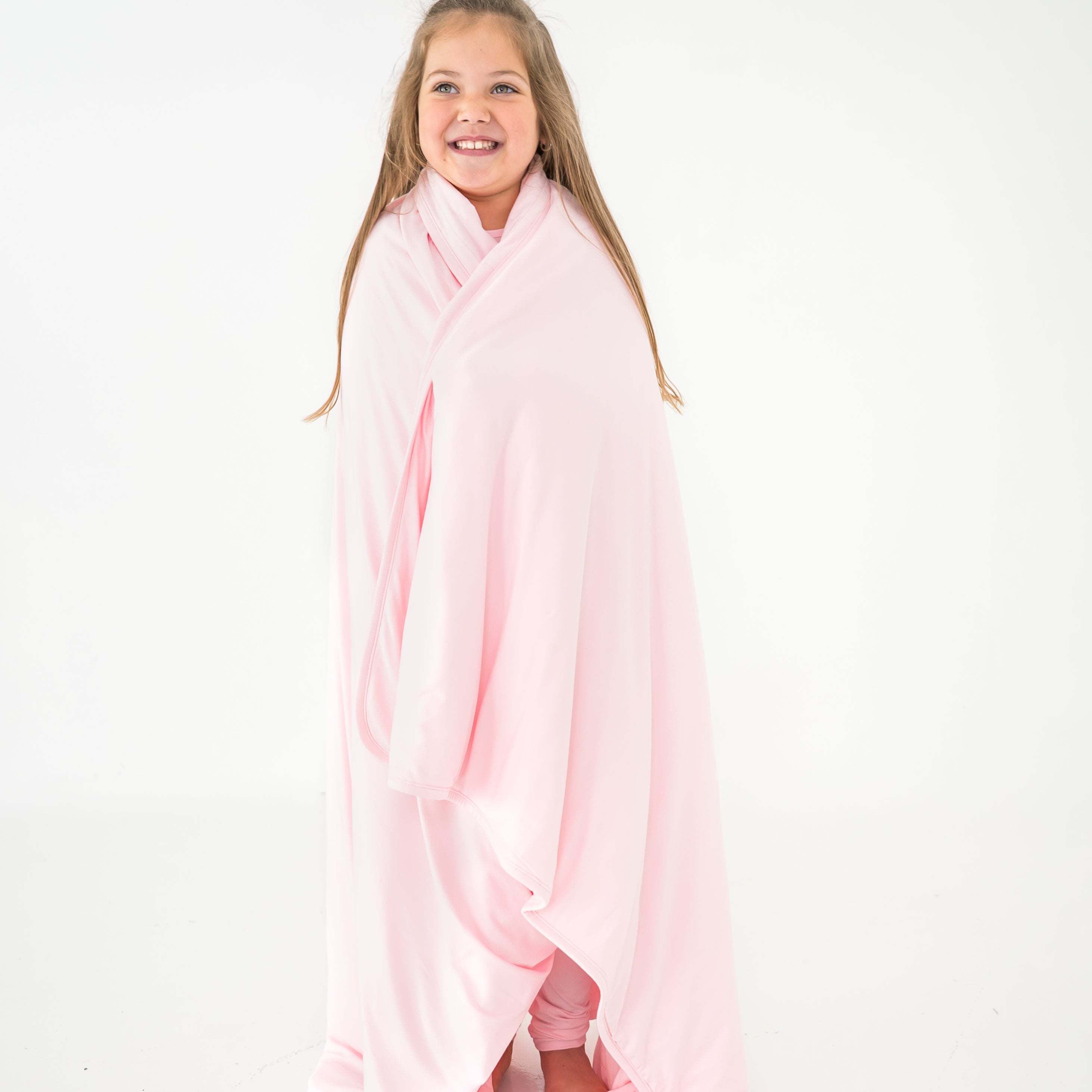 Child wrapped in a light pink blanket
