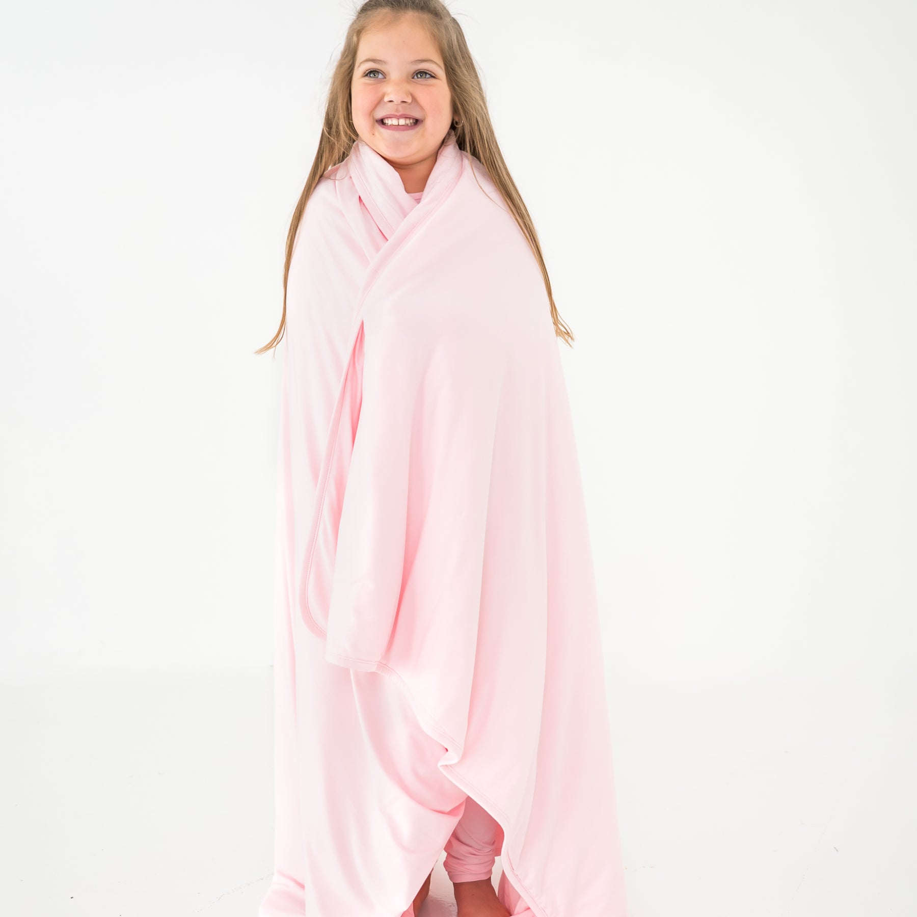 Child wrapped in a light pink blanket