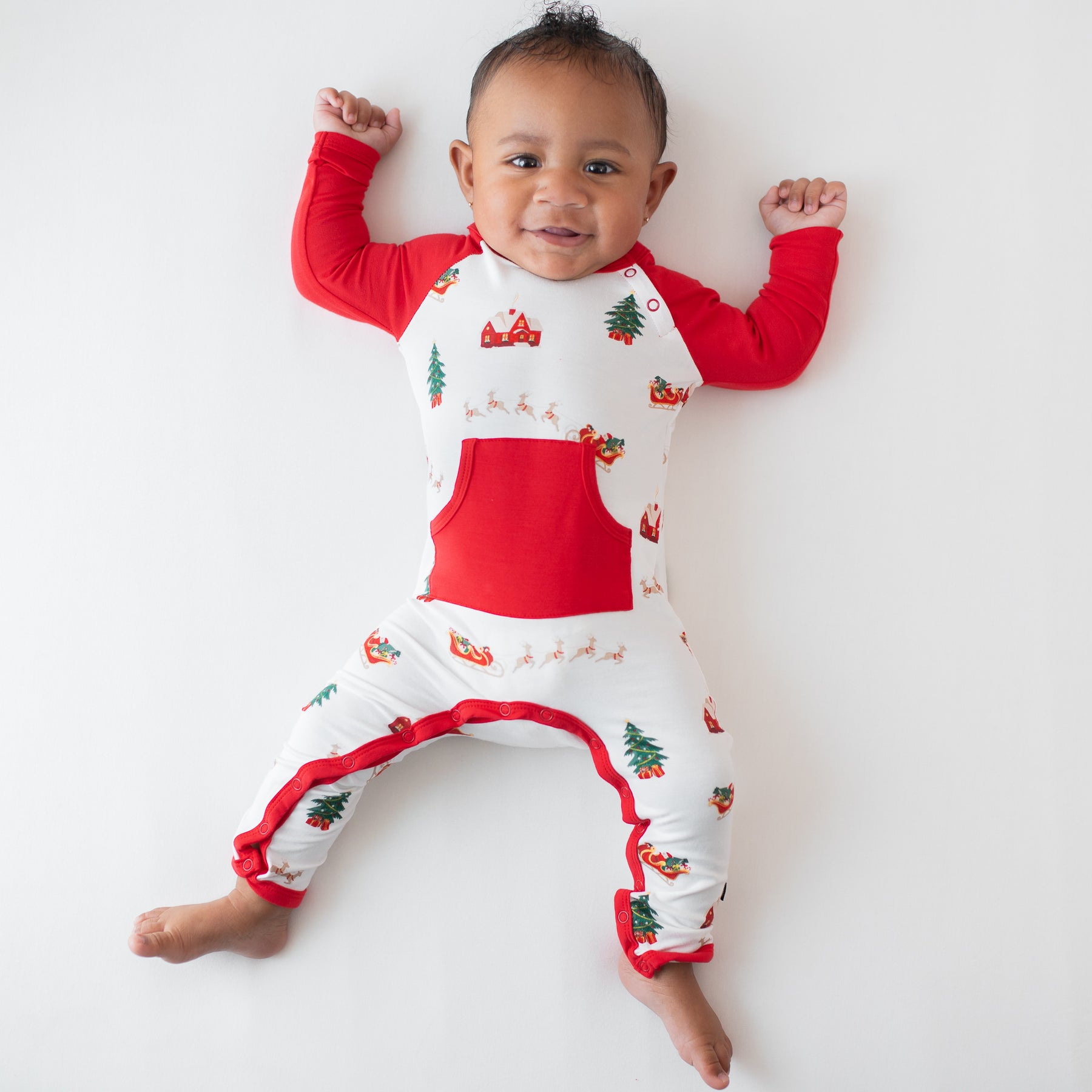 Infant laying down wearing the Longall in Santa Sleigh