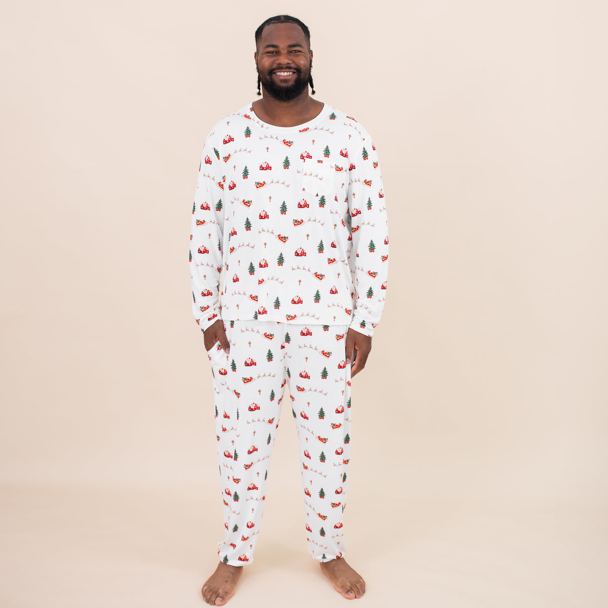 Smiling male model standing with one hand in the pants pocket of the Men's Jogger Set in Santa Sleigh