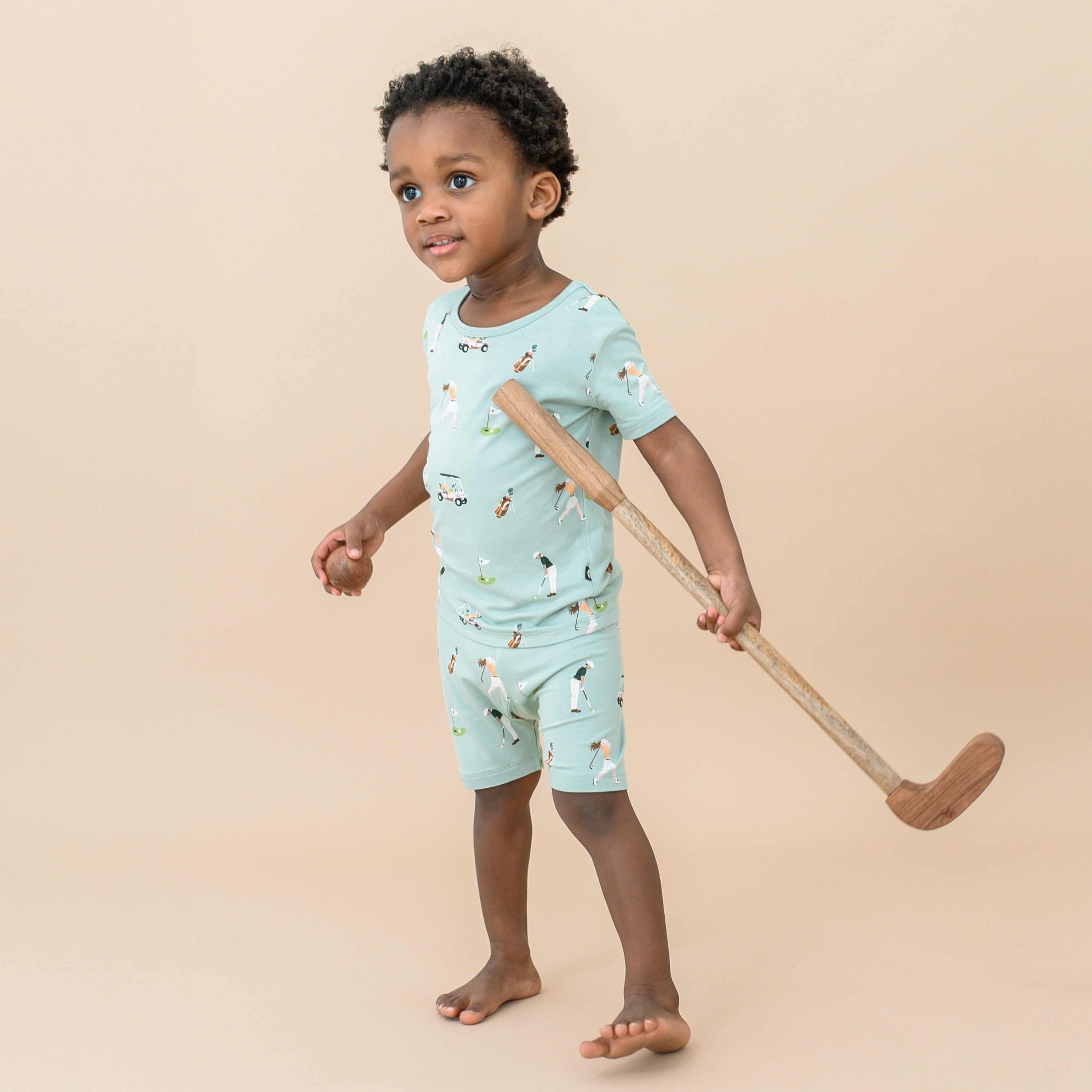 Toddler wearing Short Sleeve Pajamas in Golf with toy golf club