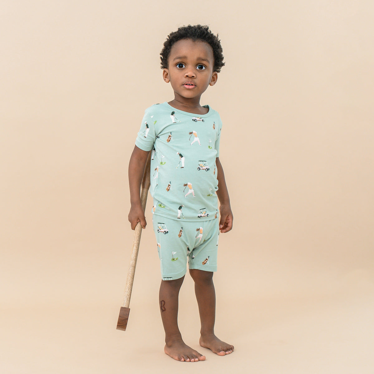 Toddler wearing Short Sleeve Pajamas in Golf with toy golf club