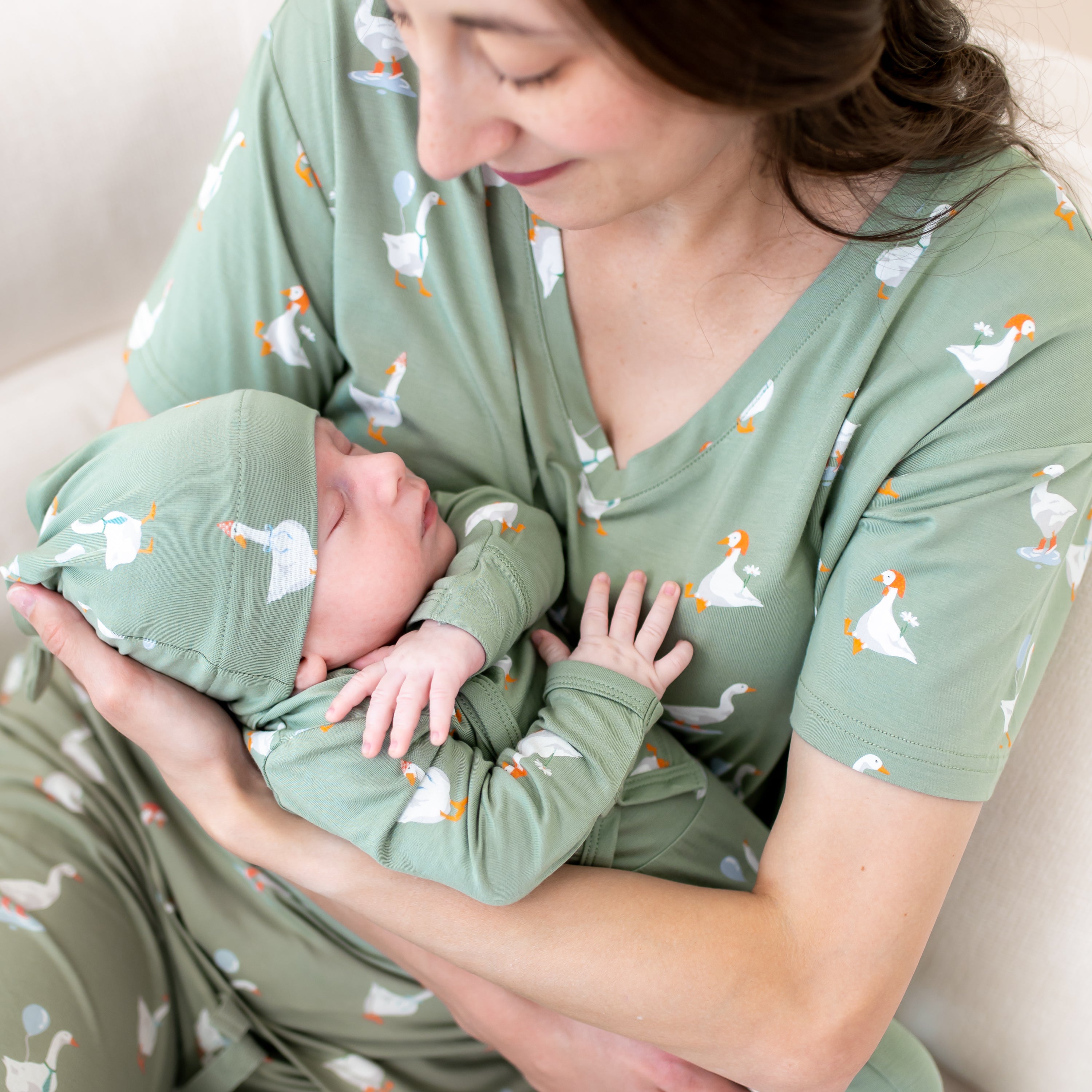 Close up of mother holding sleeping newborn wearing the Take Me Home Set in Silly Goose