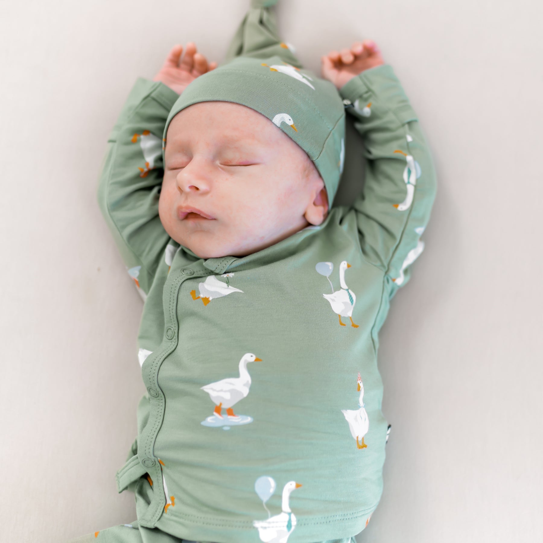 Close up of the Kimono top with snap closures of the Take Me Home Set in Silly Goose shown on a sleeping newborn with their arms above their head